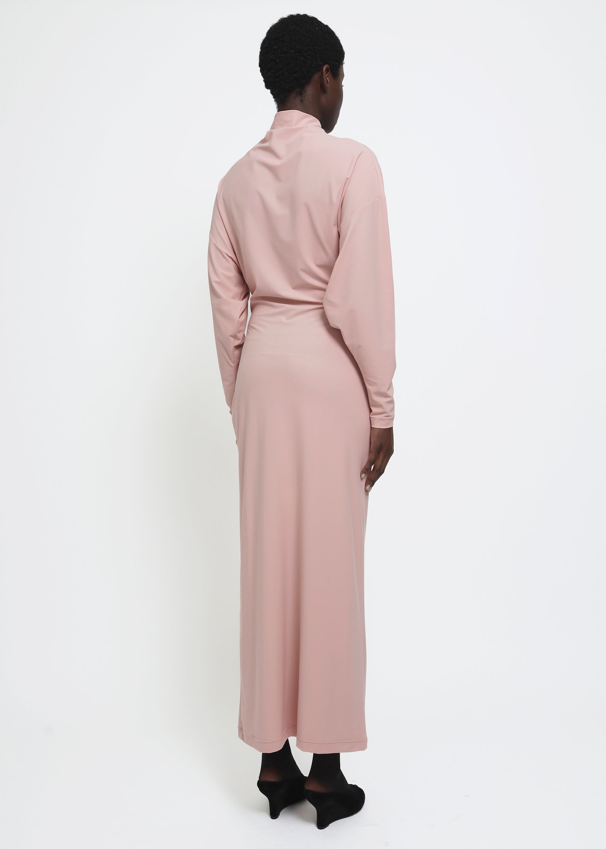 A dusty pink long-sleeve mock-neck midi dress with gathered detailing at the waist.