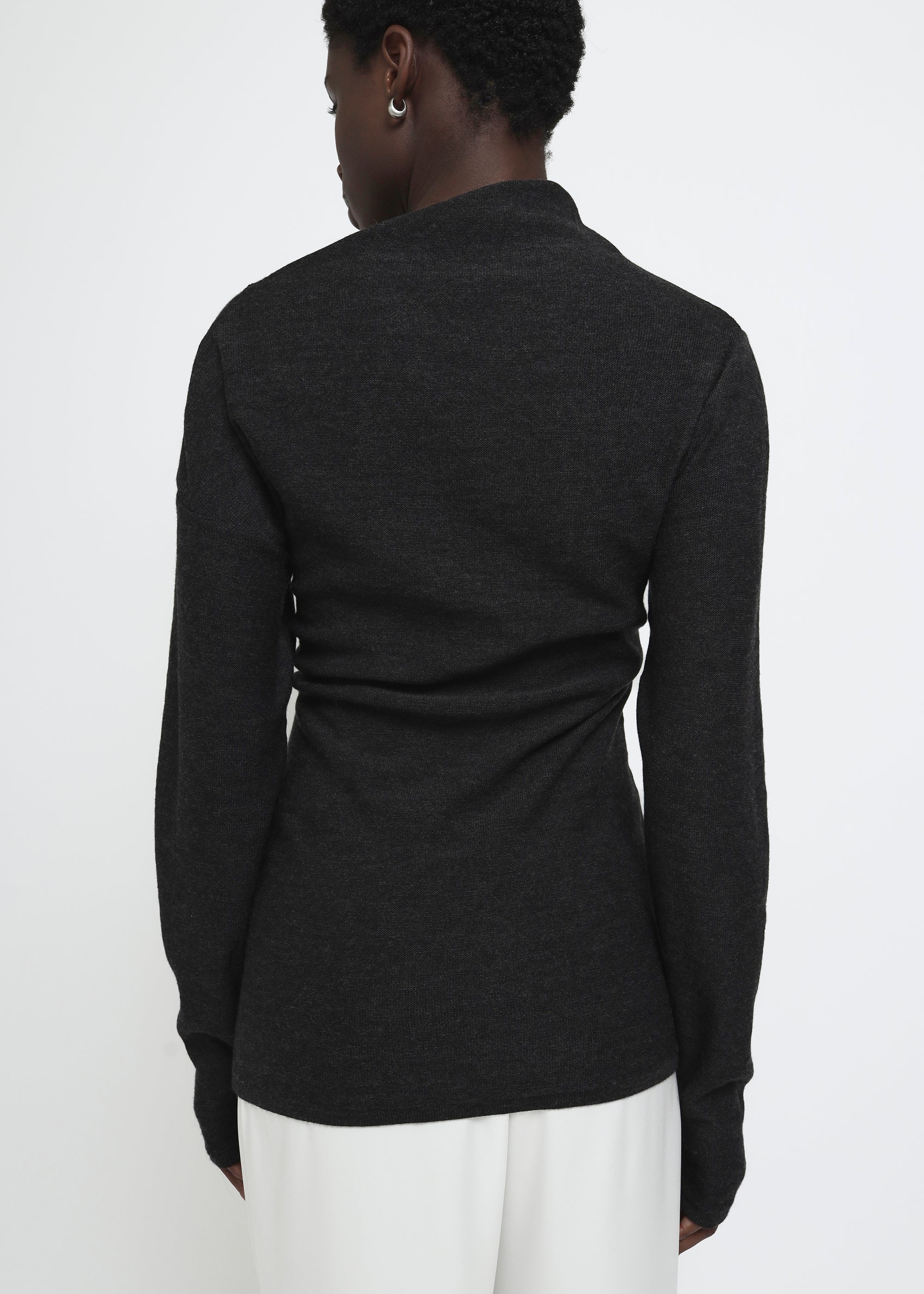 A dark gray long-sleeve knit top with a wide asymmetric neckline.