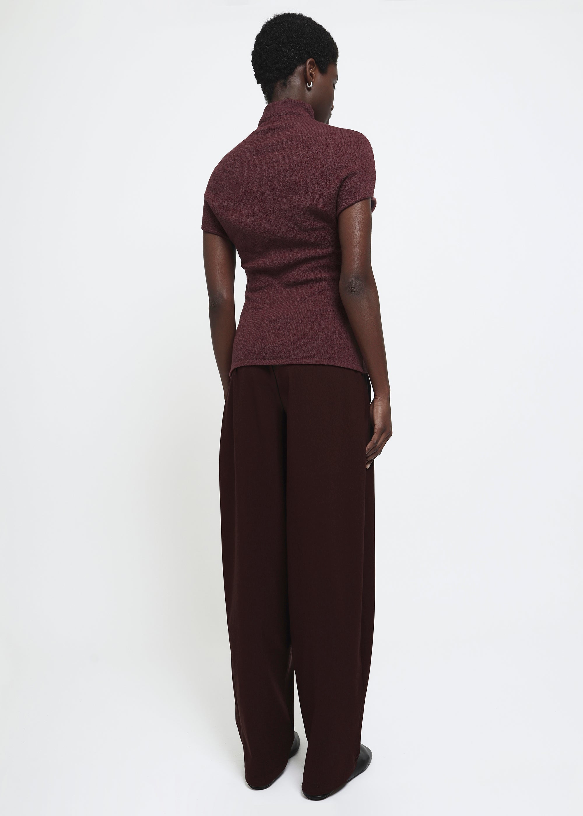 A wide-leg dark burgundy curved trousers.