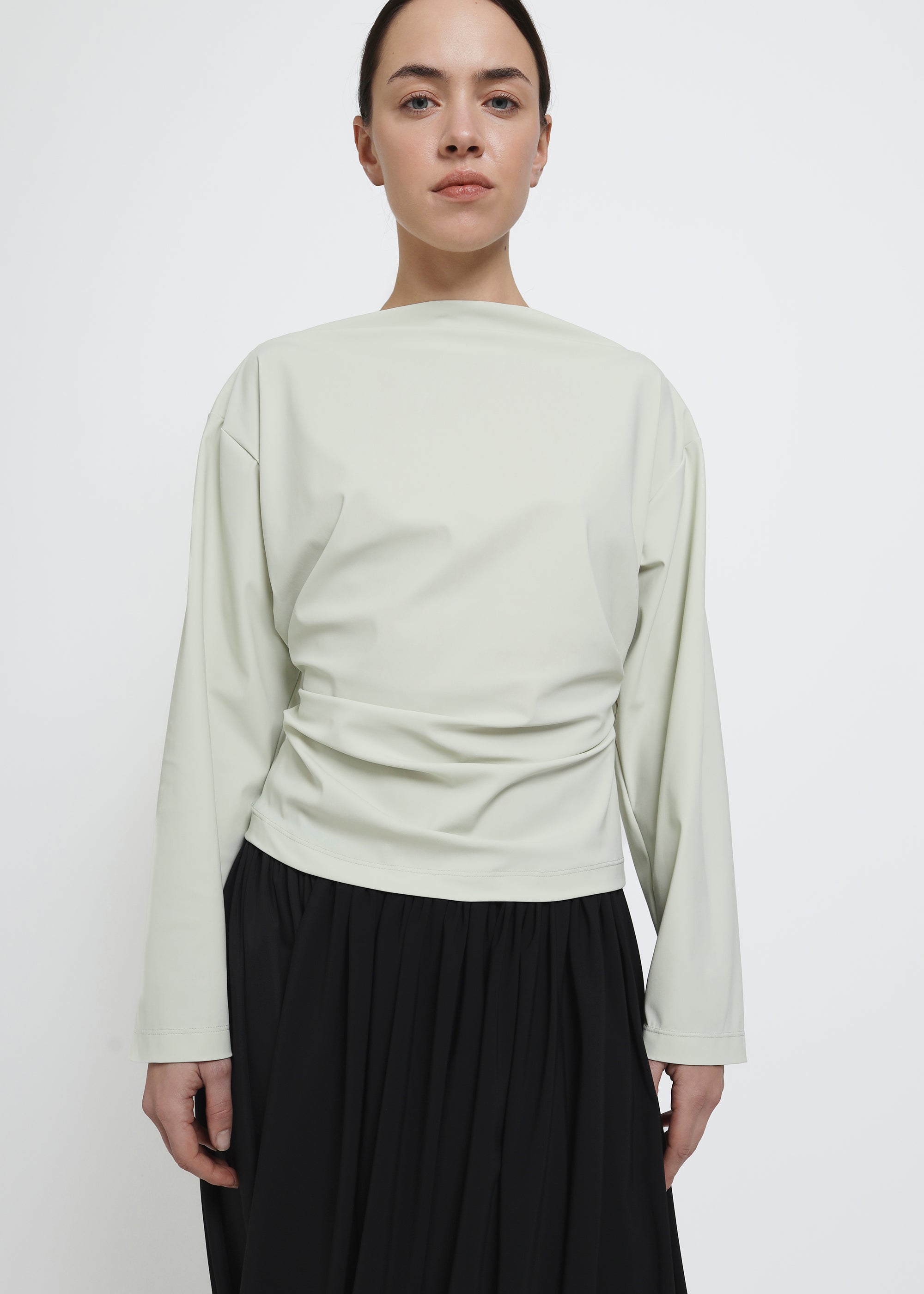 A light sage green long-sleeve top.