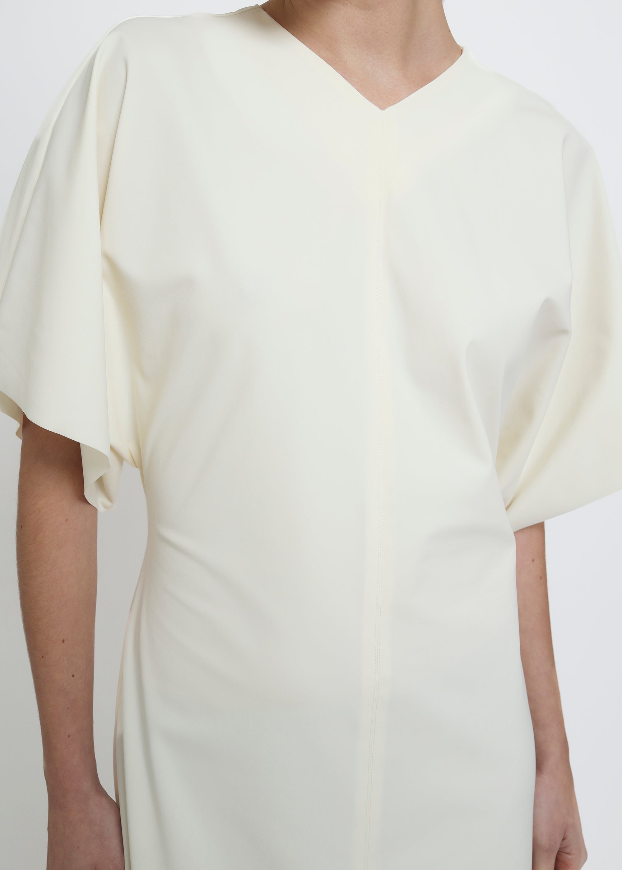 A cream-colored midi dress with short flutter sleeves.