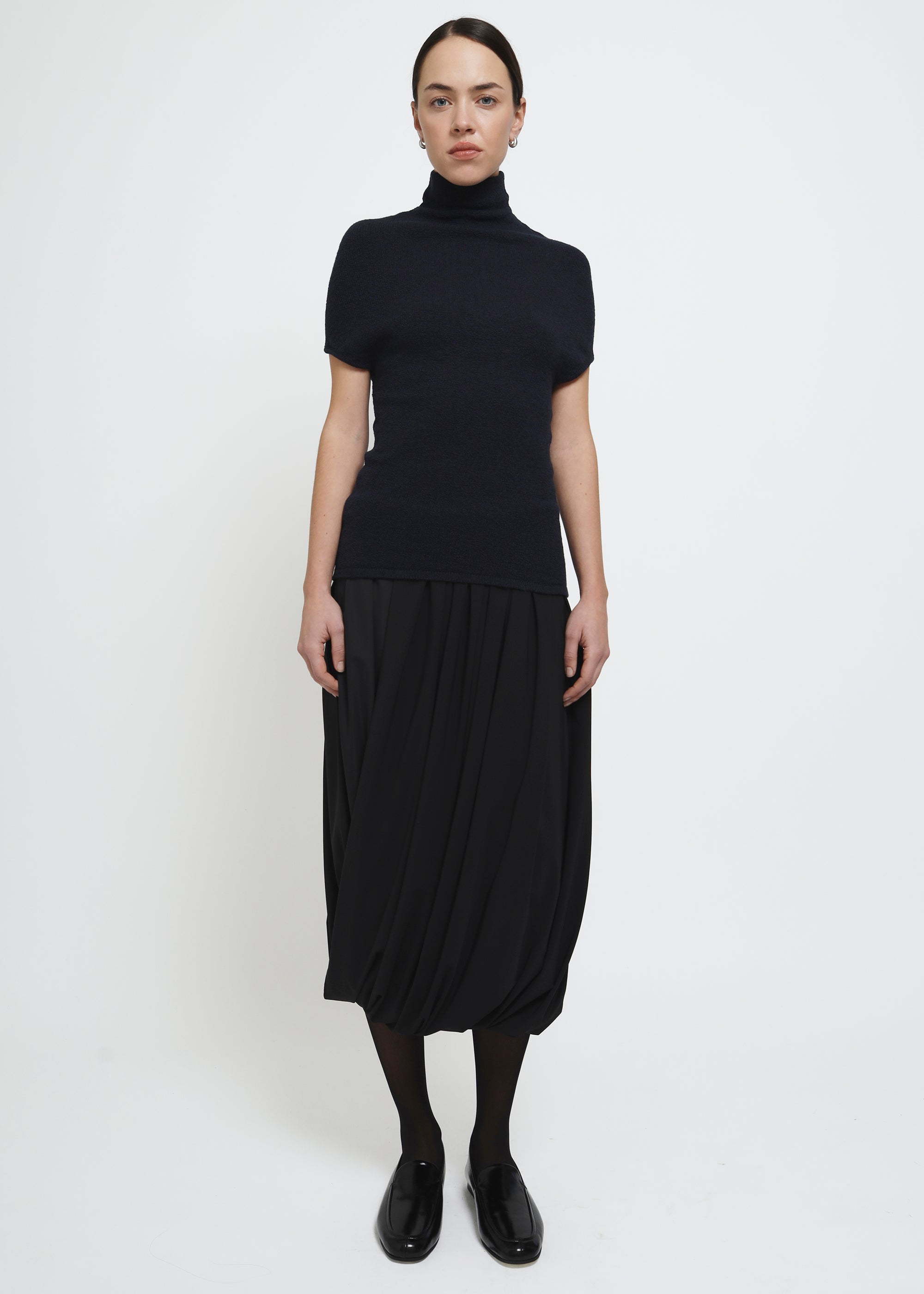 A navy cap-sleeve mock neck top in a textured bouclé like yarn.