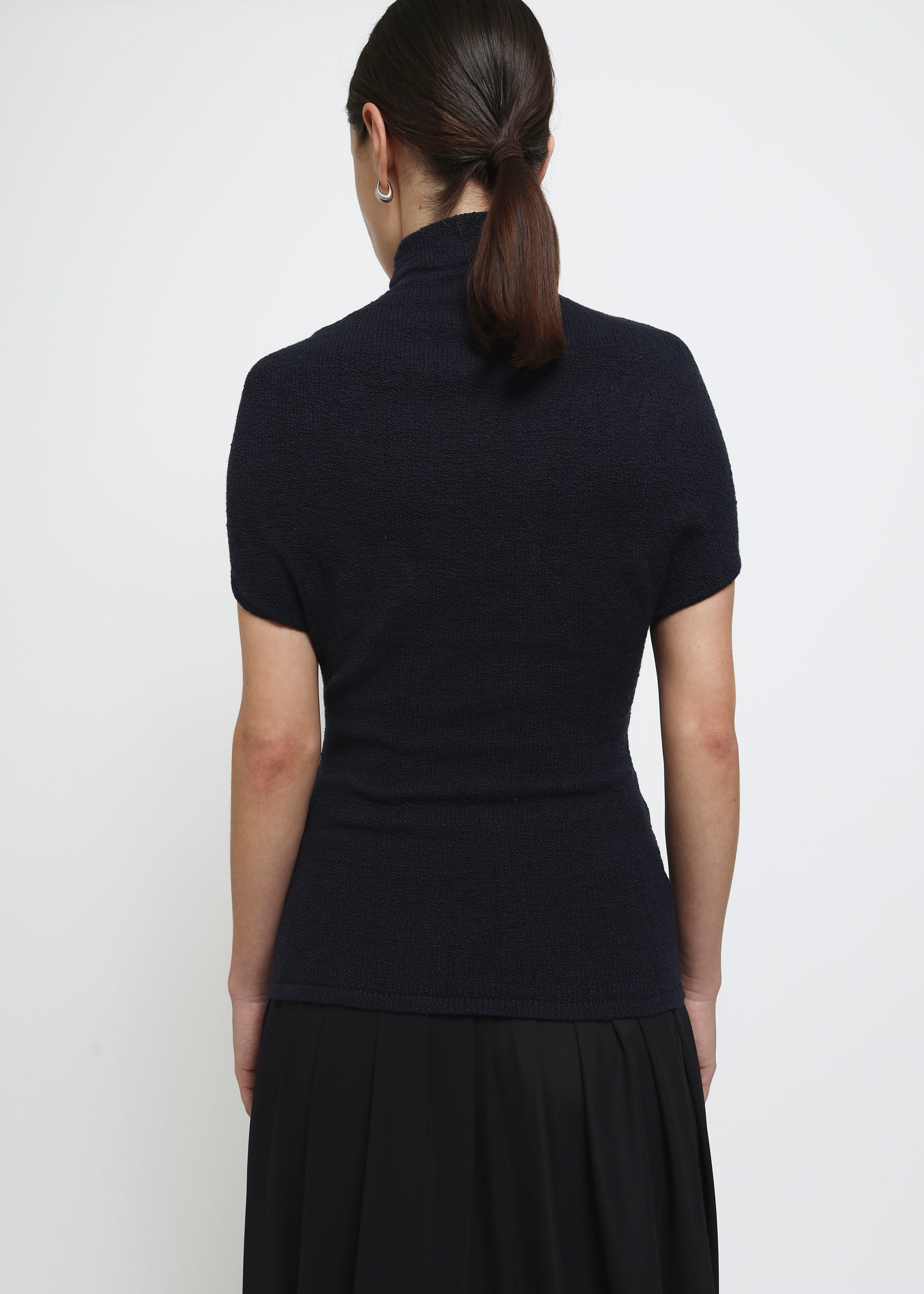 A navy cap-sleeve mock neck top in a textured bouclé like yarn.
