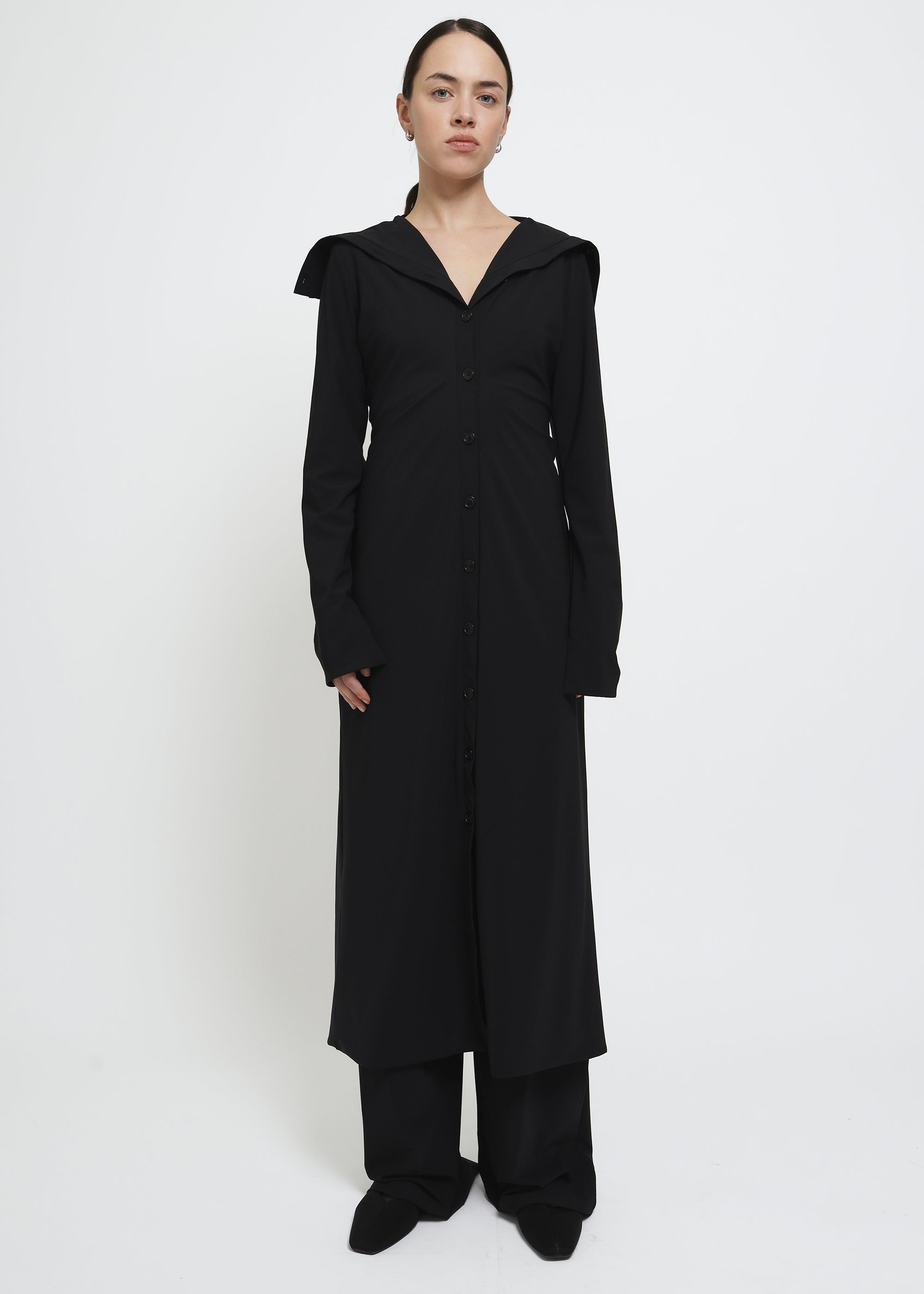 A long black button-front cardigan dress with wide lapels and draped shoulders.