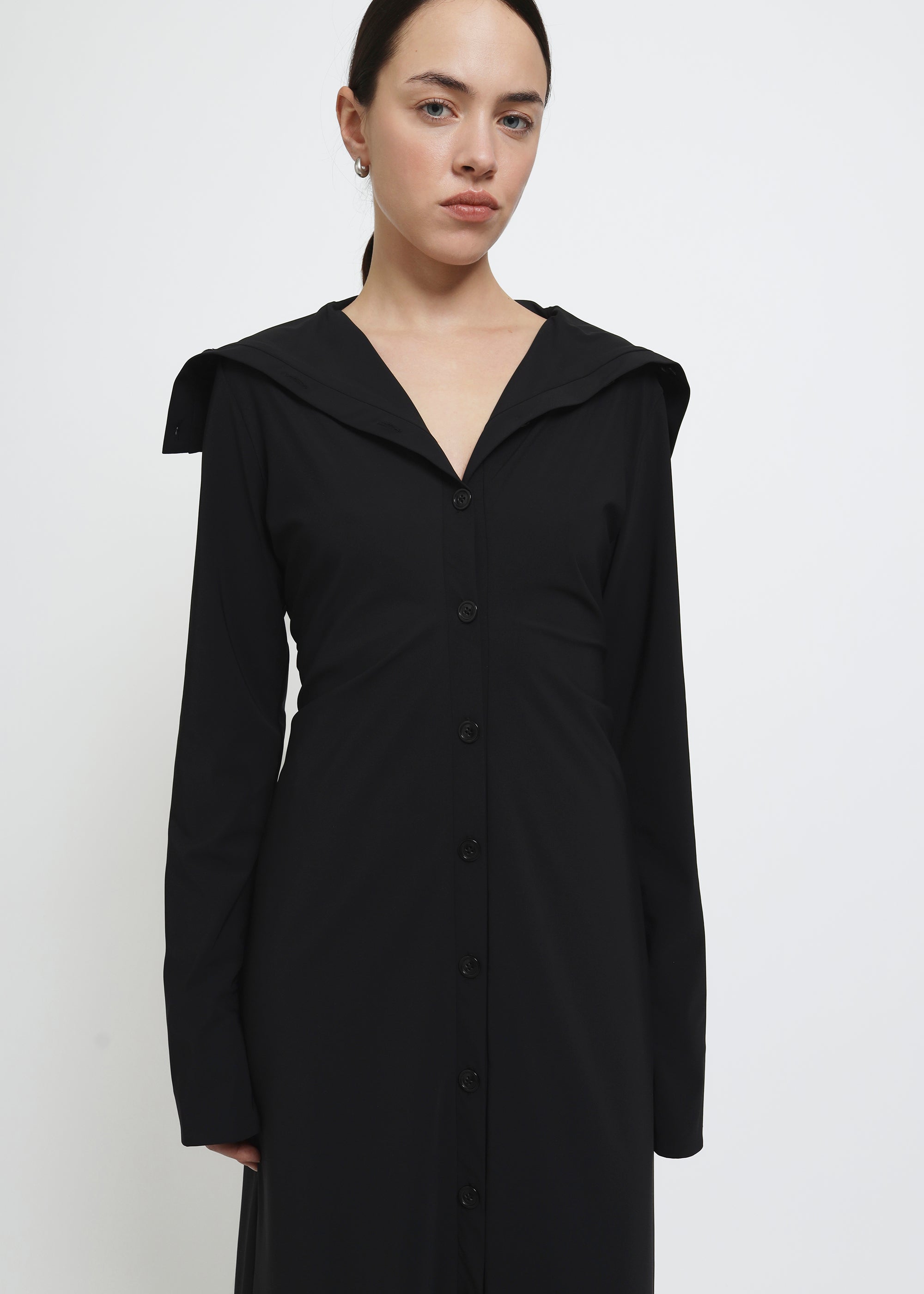 A long black button-front cardigan dress with wide lapels and draped shoulders.