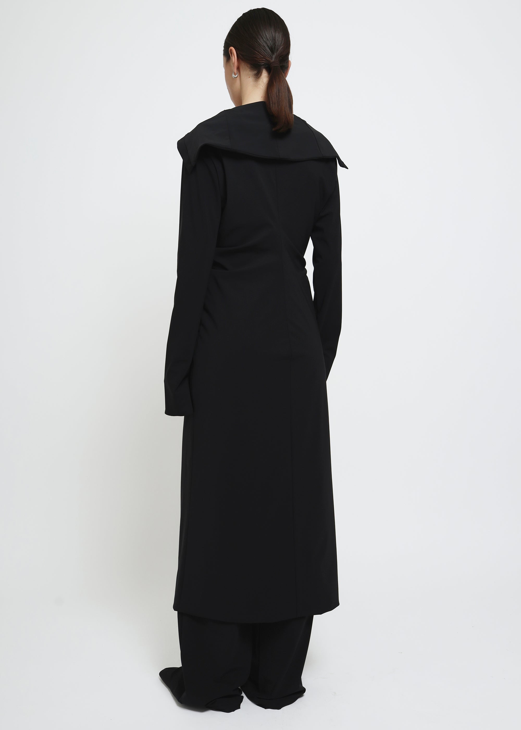 A long black button-front cardigan dress with wide lapels and draped shoulders.