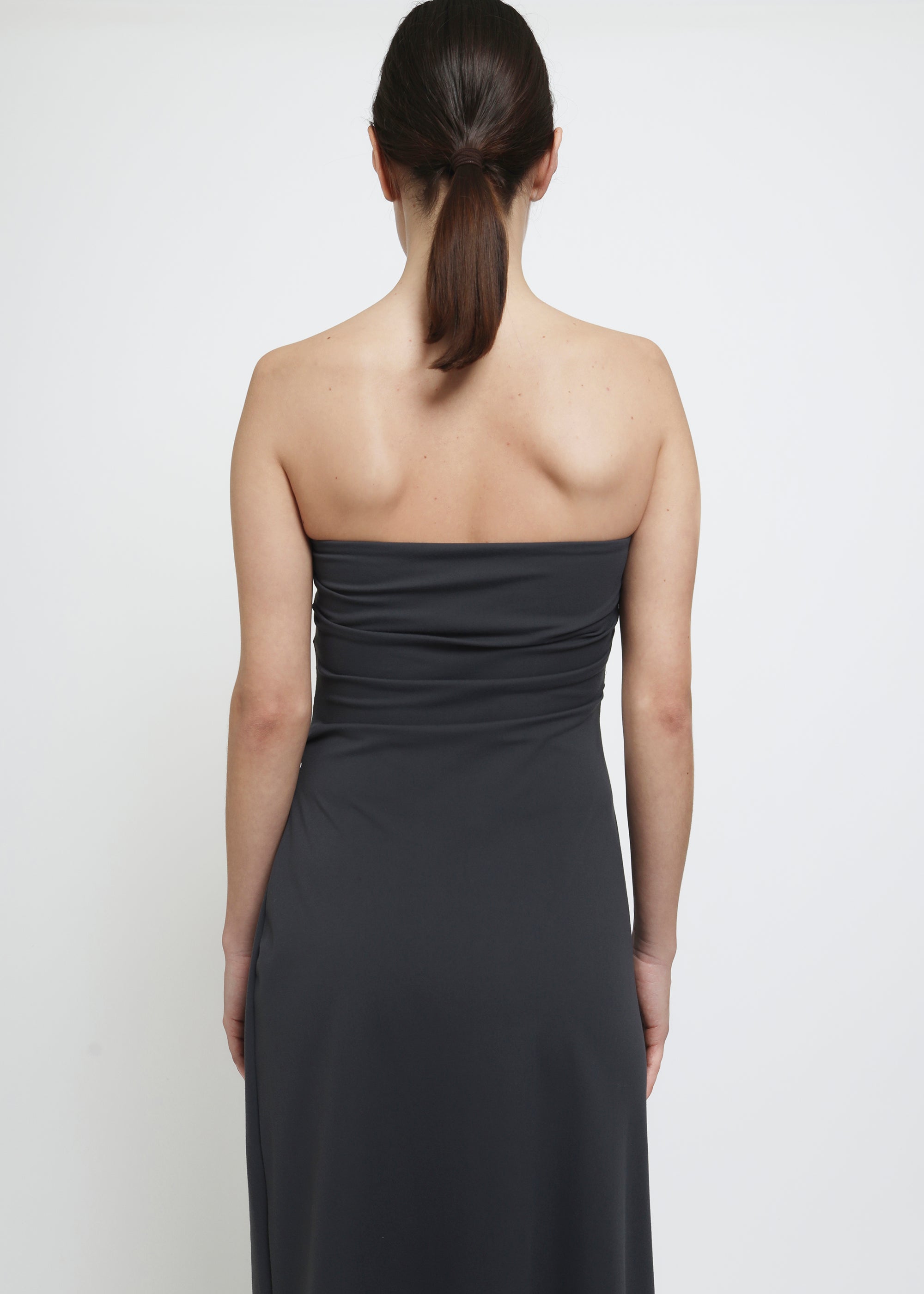A dark gray strapless midi dress with a draped bodice.