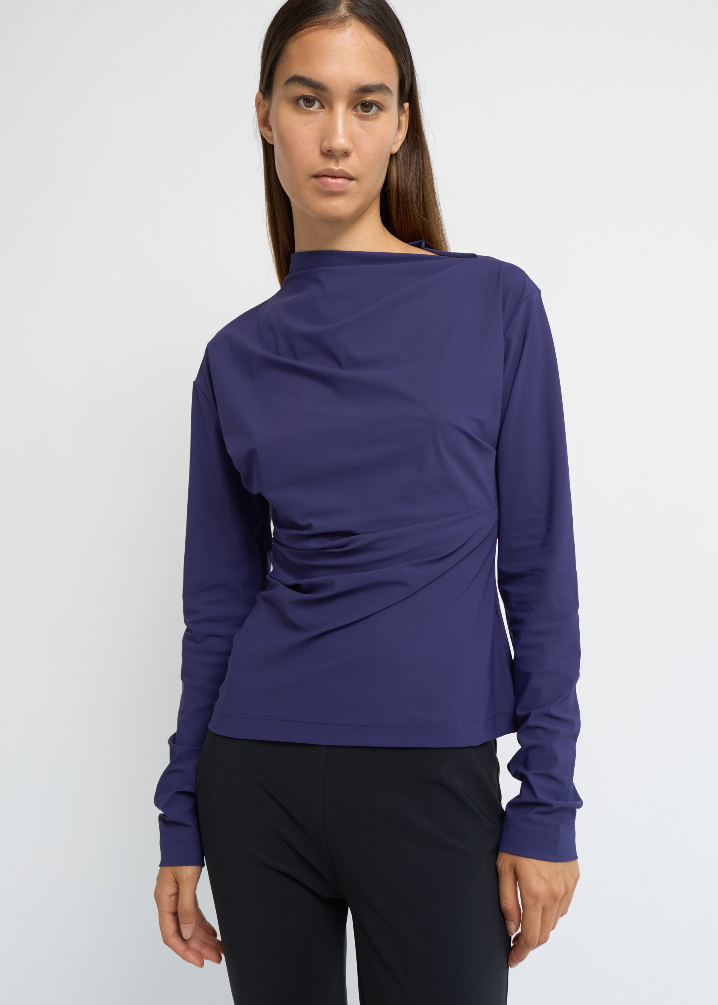 Violet long-sleeve top with an asymmetrical neckline and soft waist folds