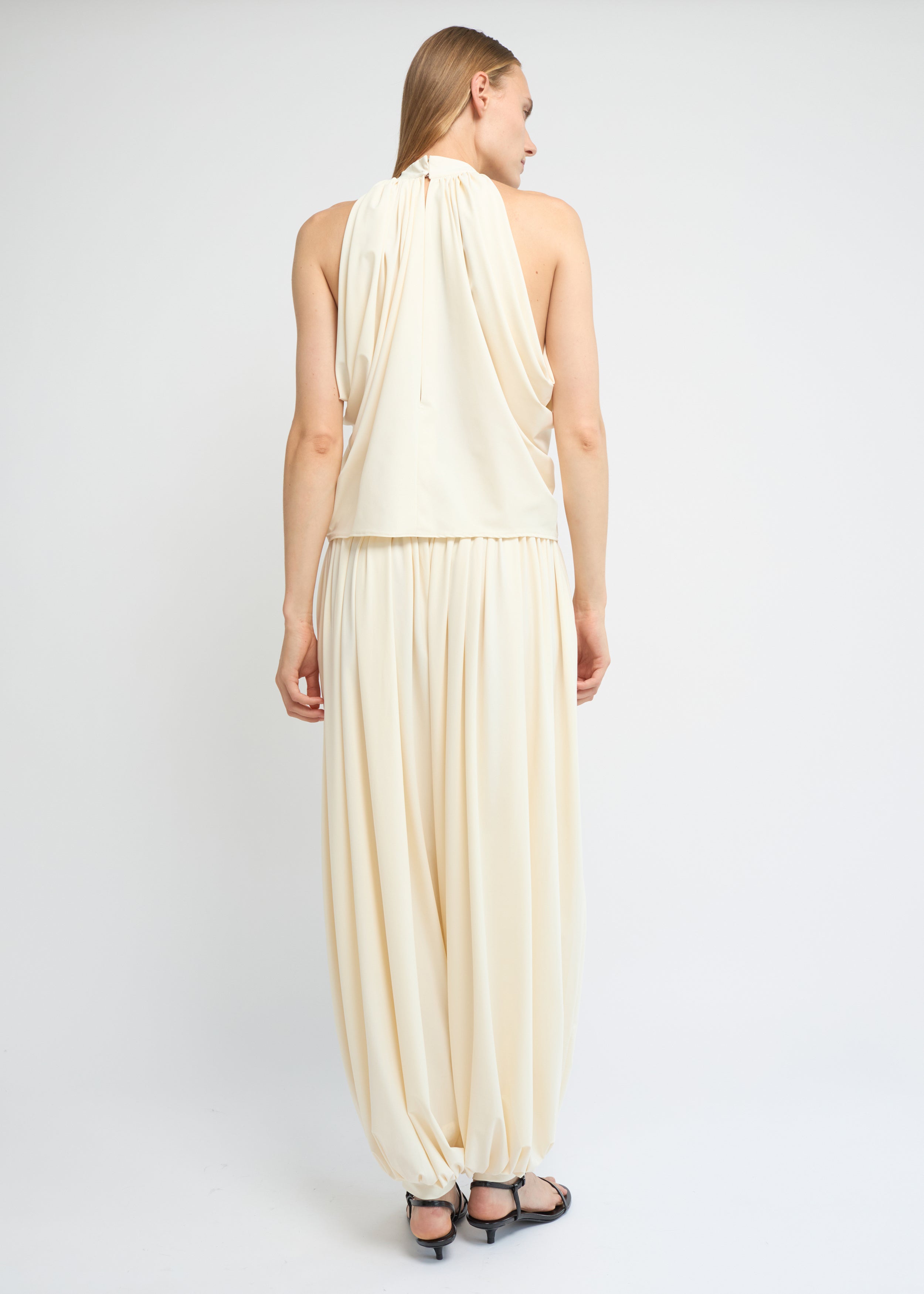 Cream balloon pants with a voluminous gathered silhouette and cuffed hems