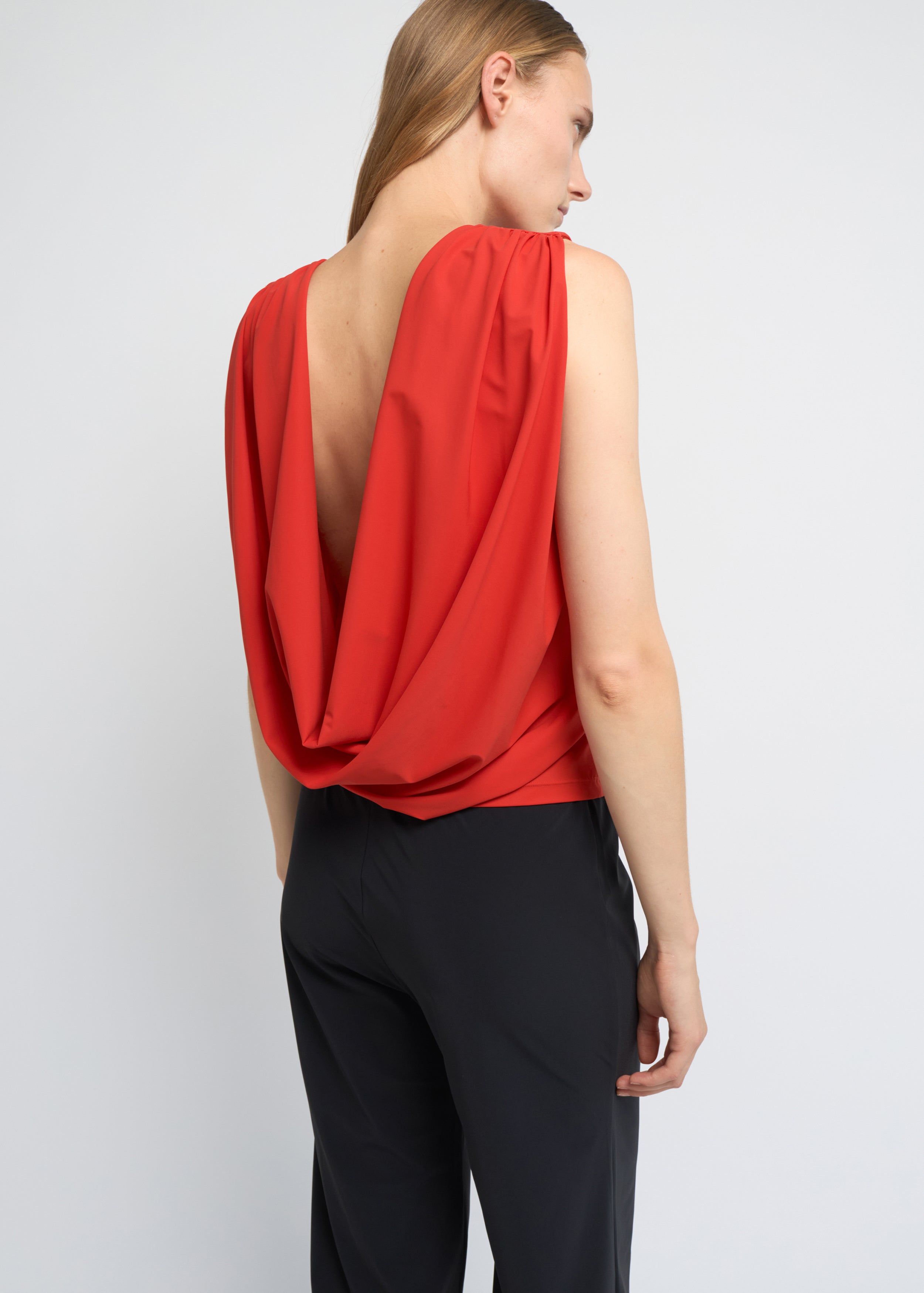 Red sleeveless top with a high neckline and softly draped open back