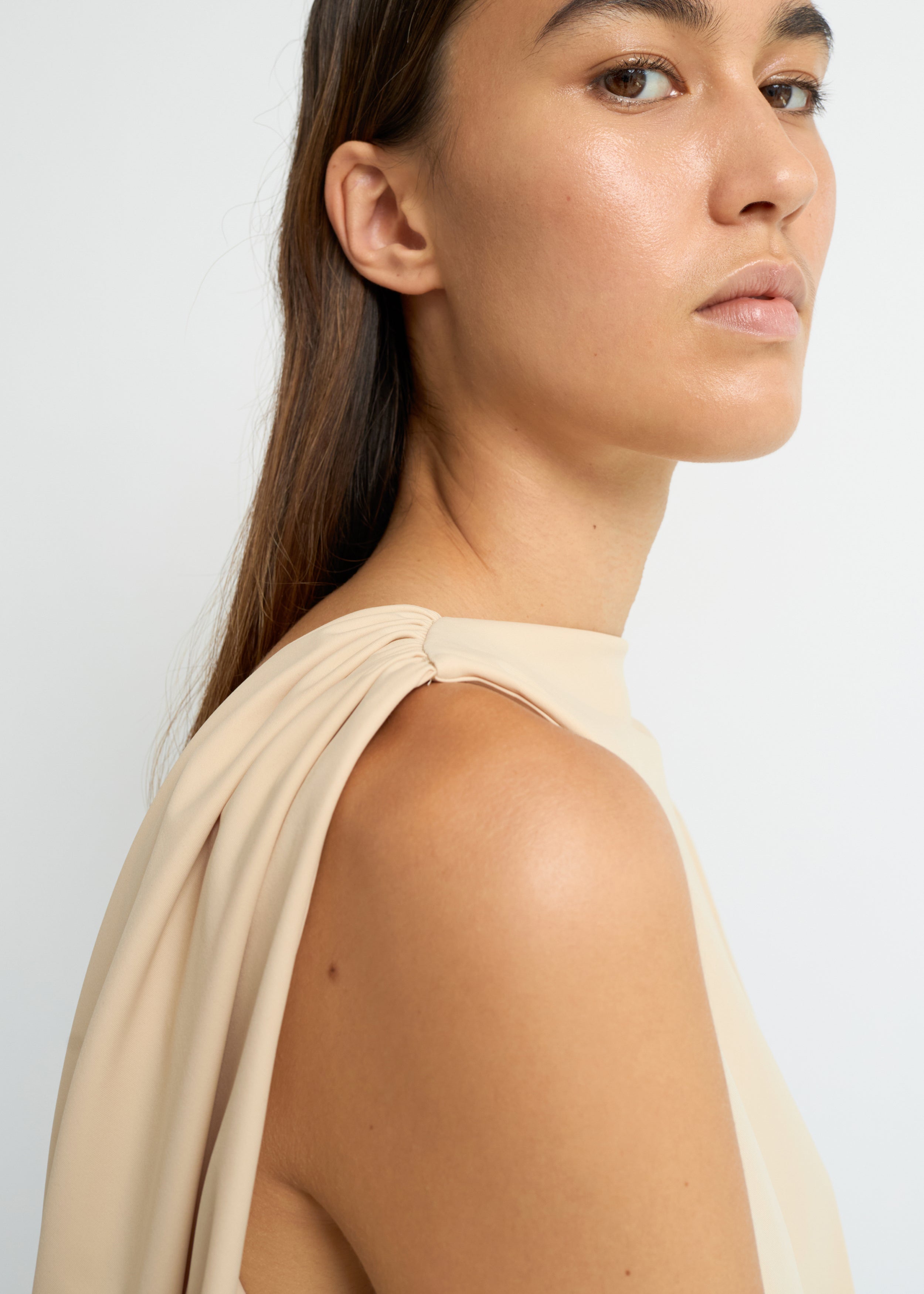 Sand sleeveless top with a high neckline and open back