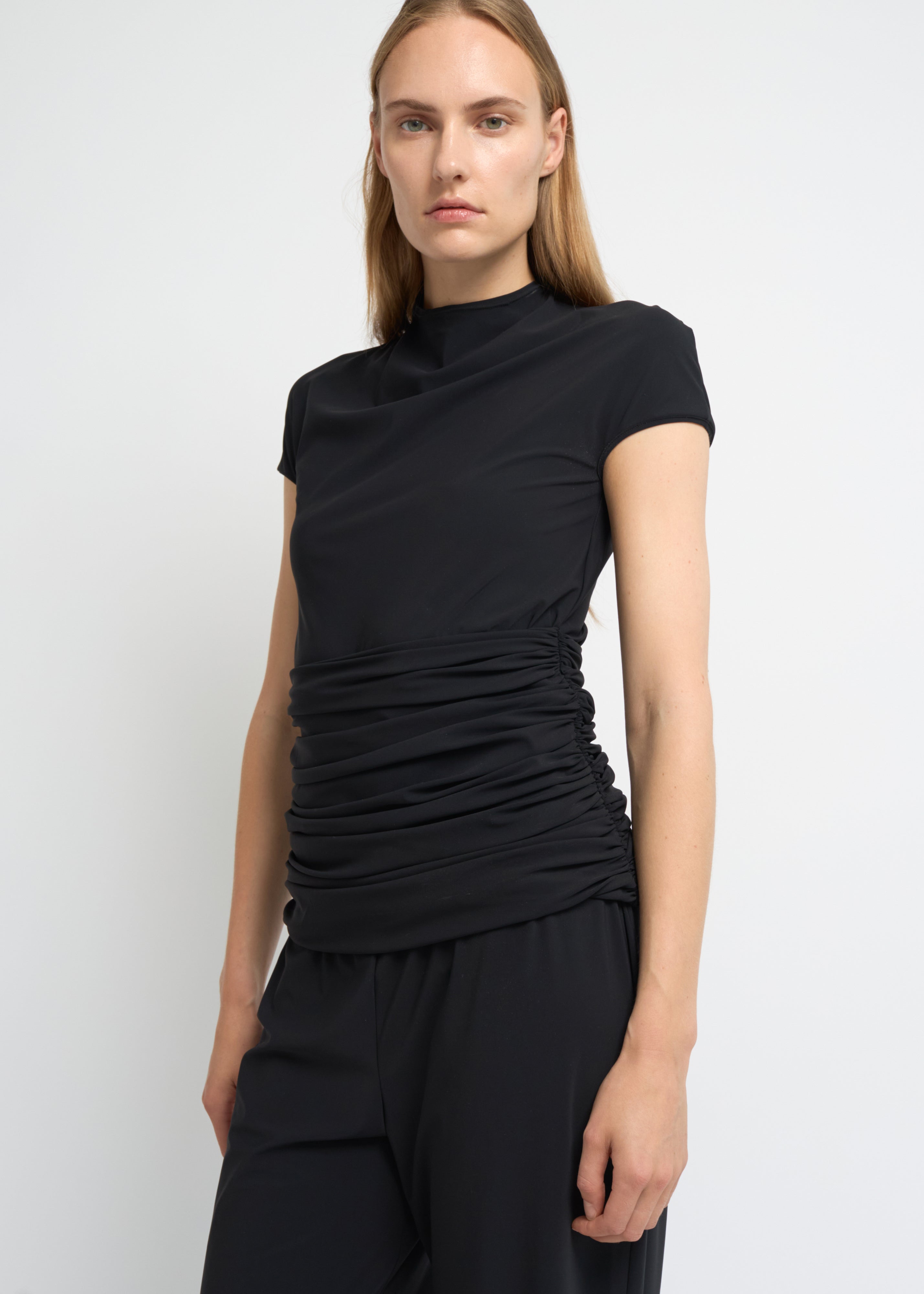 Black fitted short-sleeve top with a high neckline and soft gathers at the waist