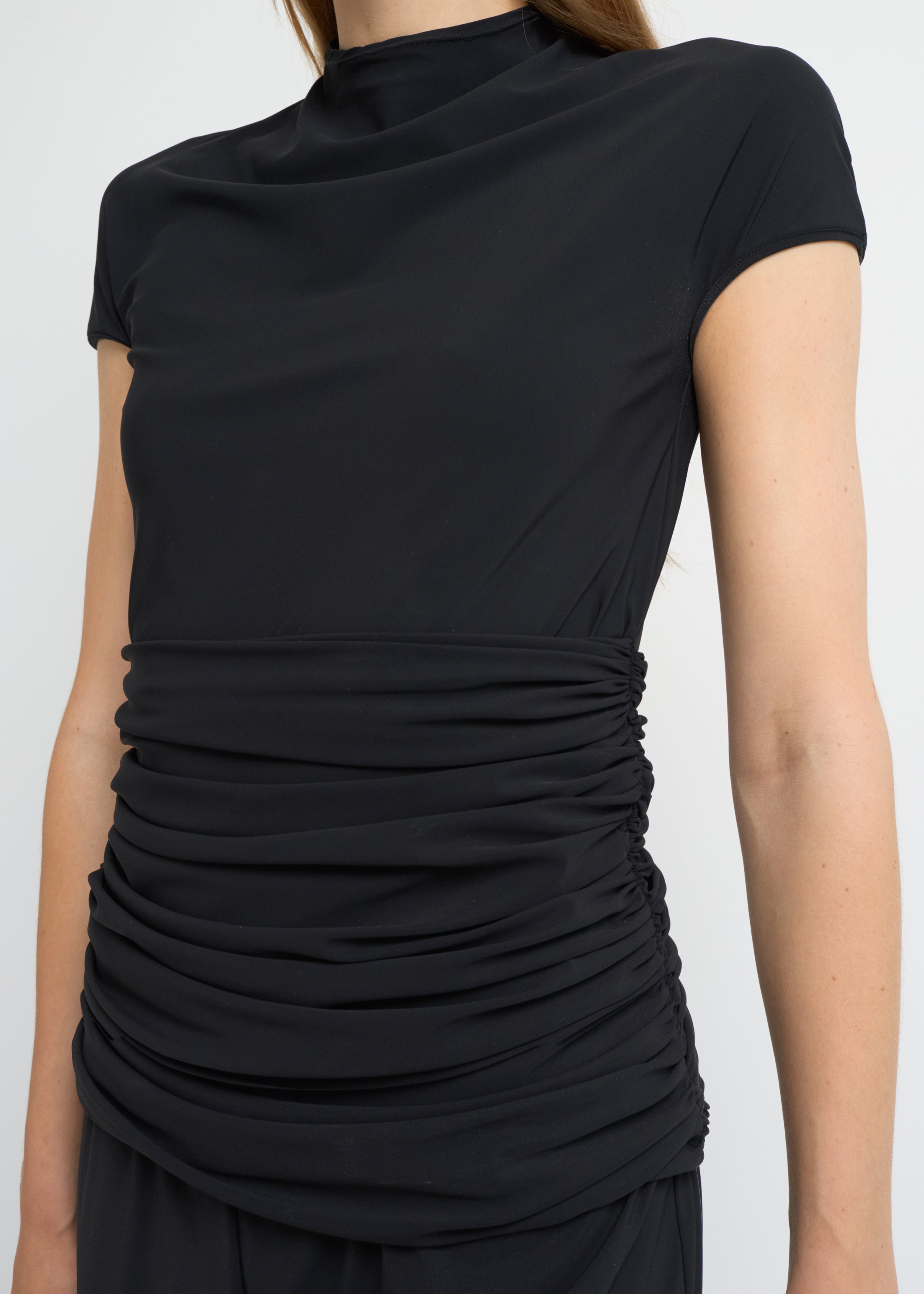 Black fitted short-sleeve top with a high neckline and soft gathers at the waist