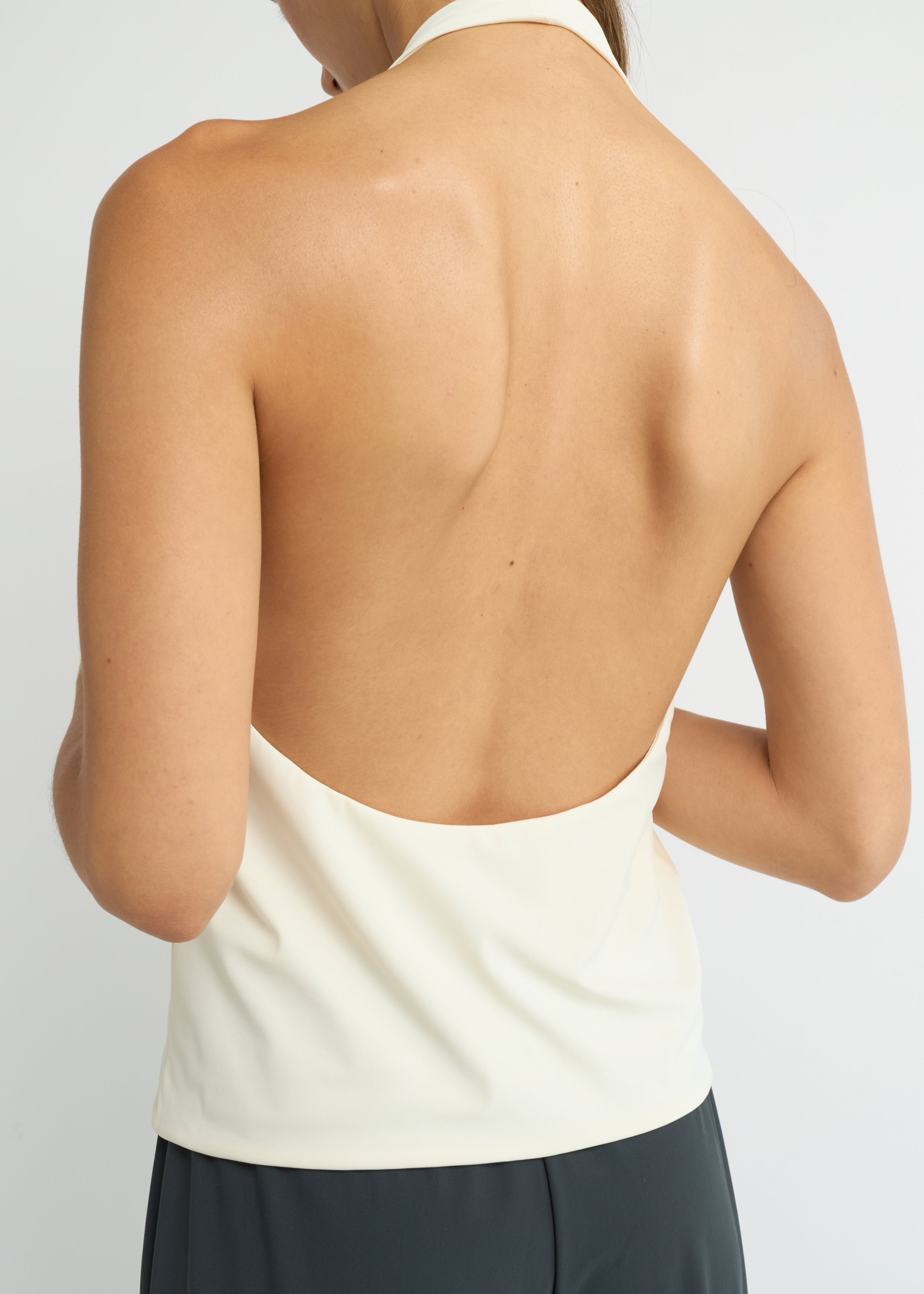 Cream halter neck top with a deep scoop neckline and open back