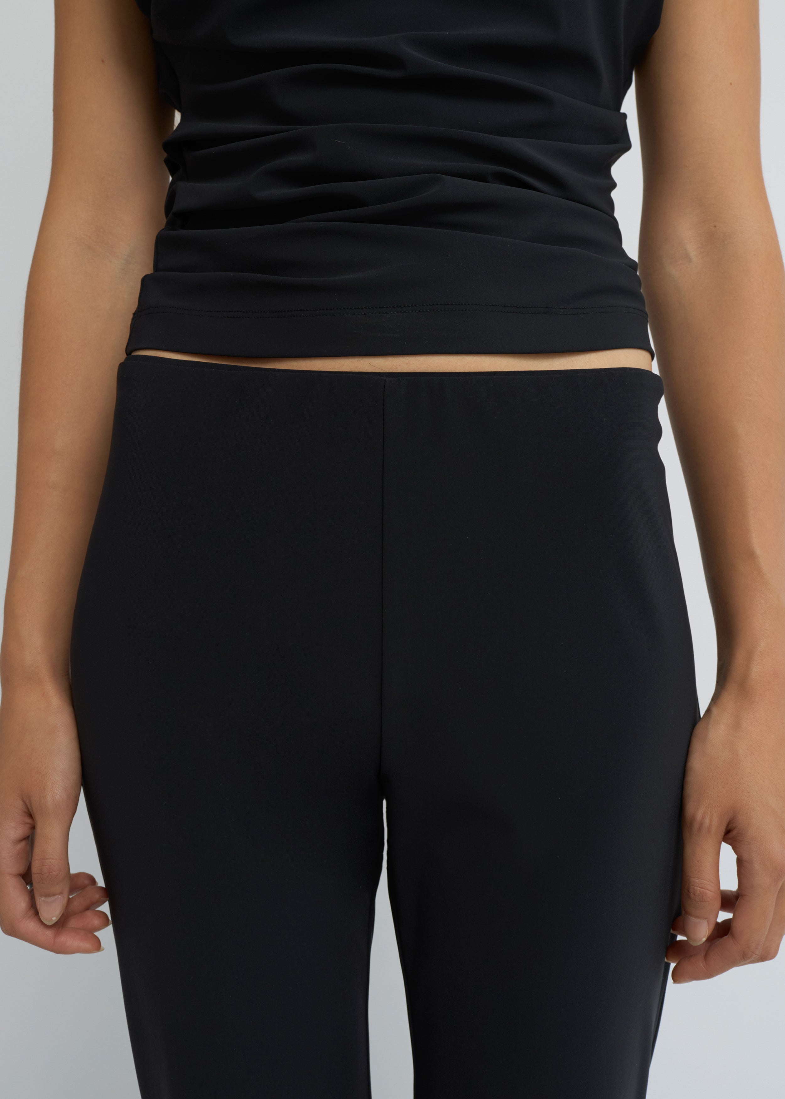 Black cropped kick-flare pants with a subtle flare at the hem