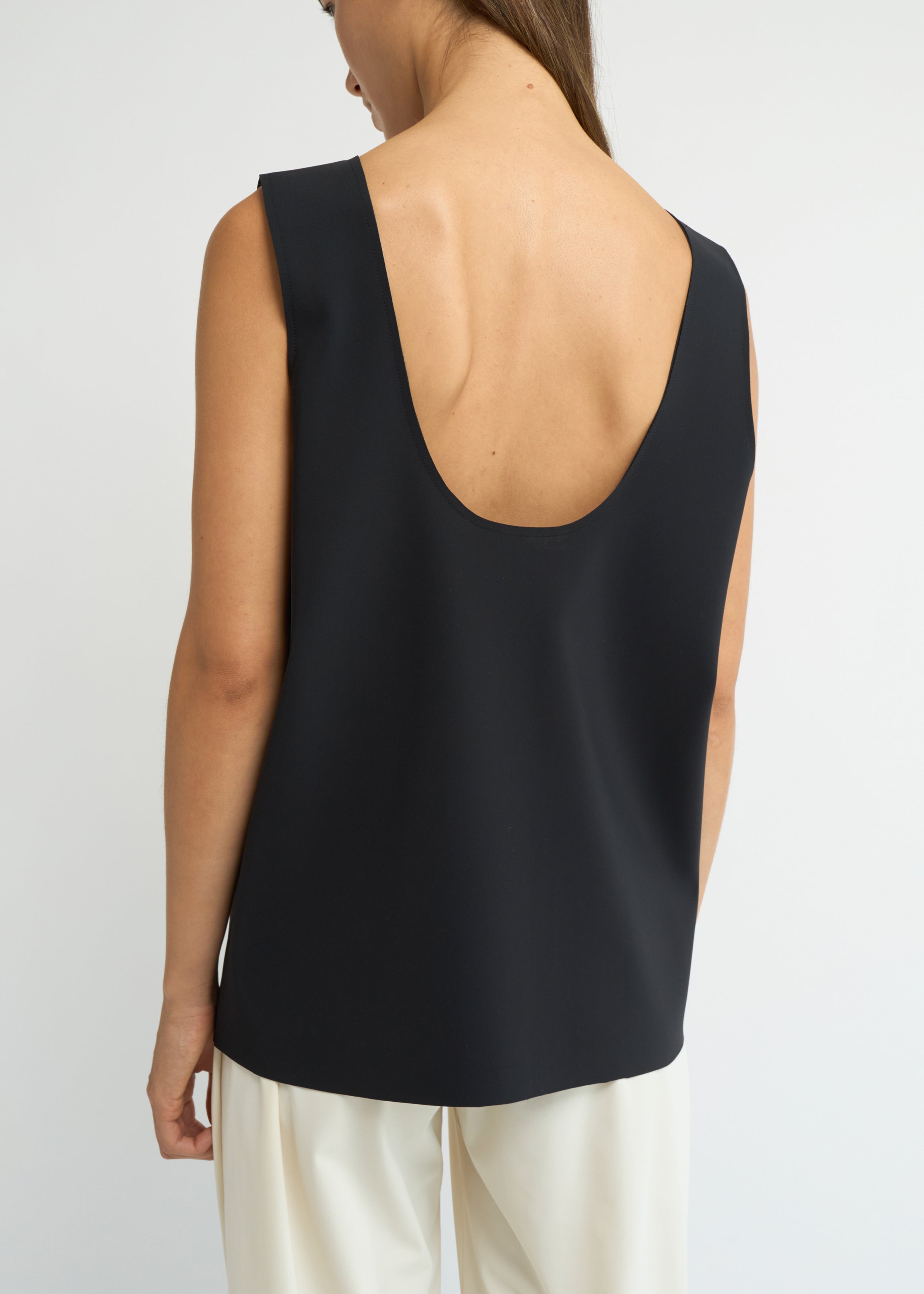 Black sleeveless scoop-neck top with a structured, elongated line
