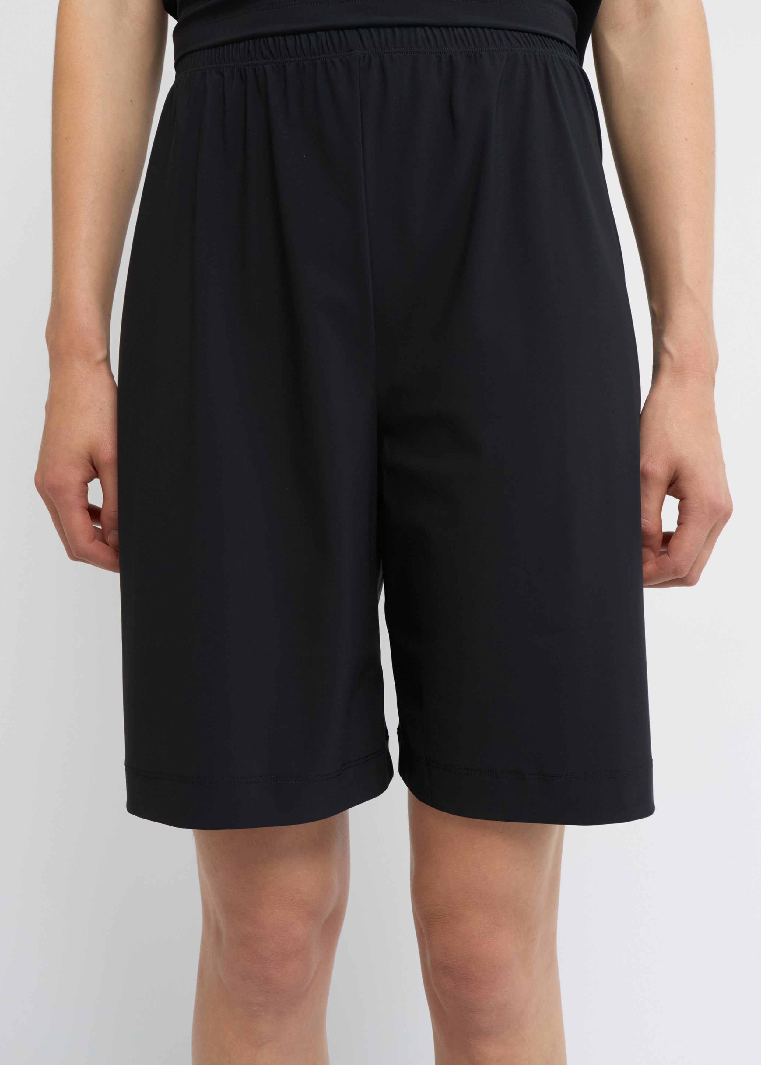 Black wide-fit shorts with a relaxed silhouette and elasticated waistband