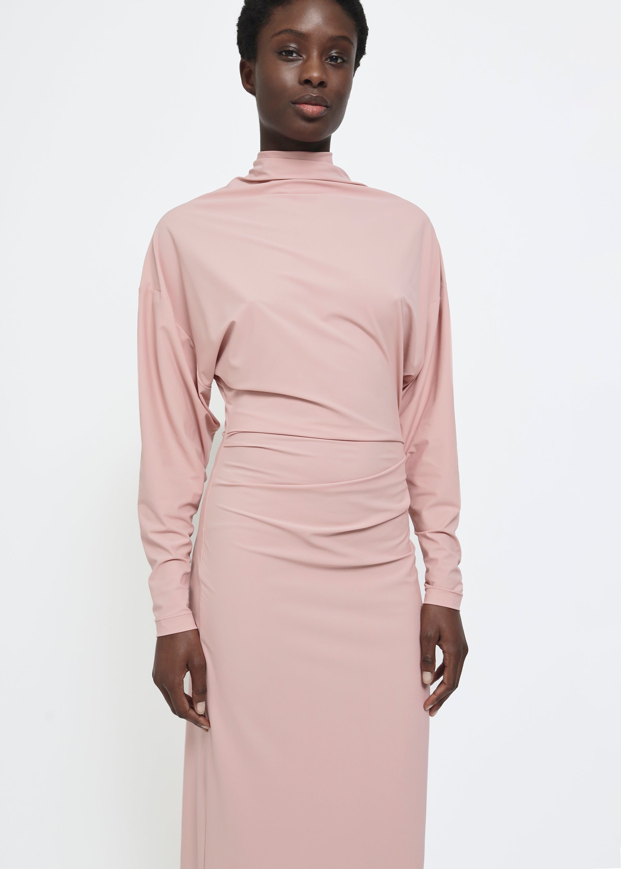 A dusty pink long-sleeve mock-neck midi dress with gathered detailing at the waist.