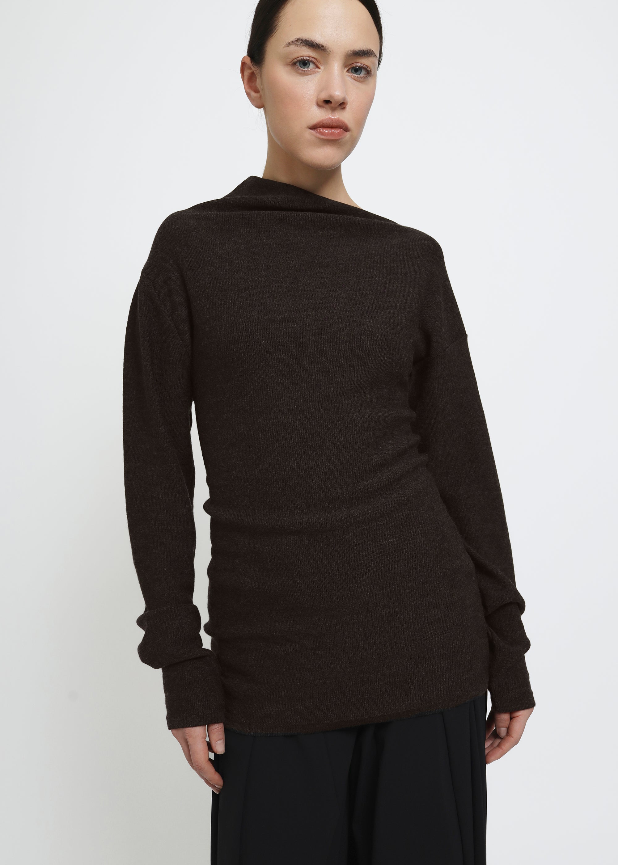 A dark brown long-sleeve knit top with a wide asymmetric neckline.