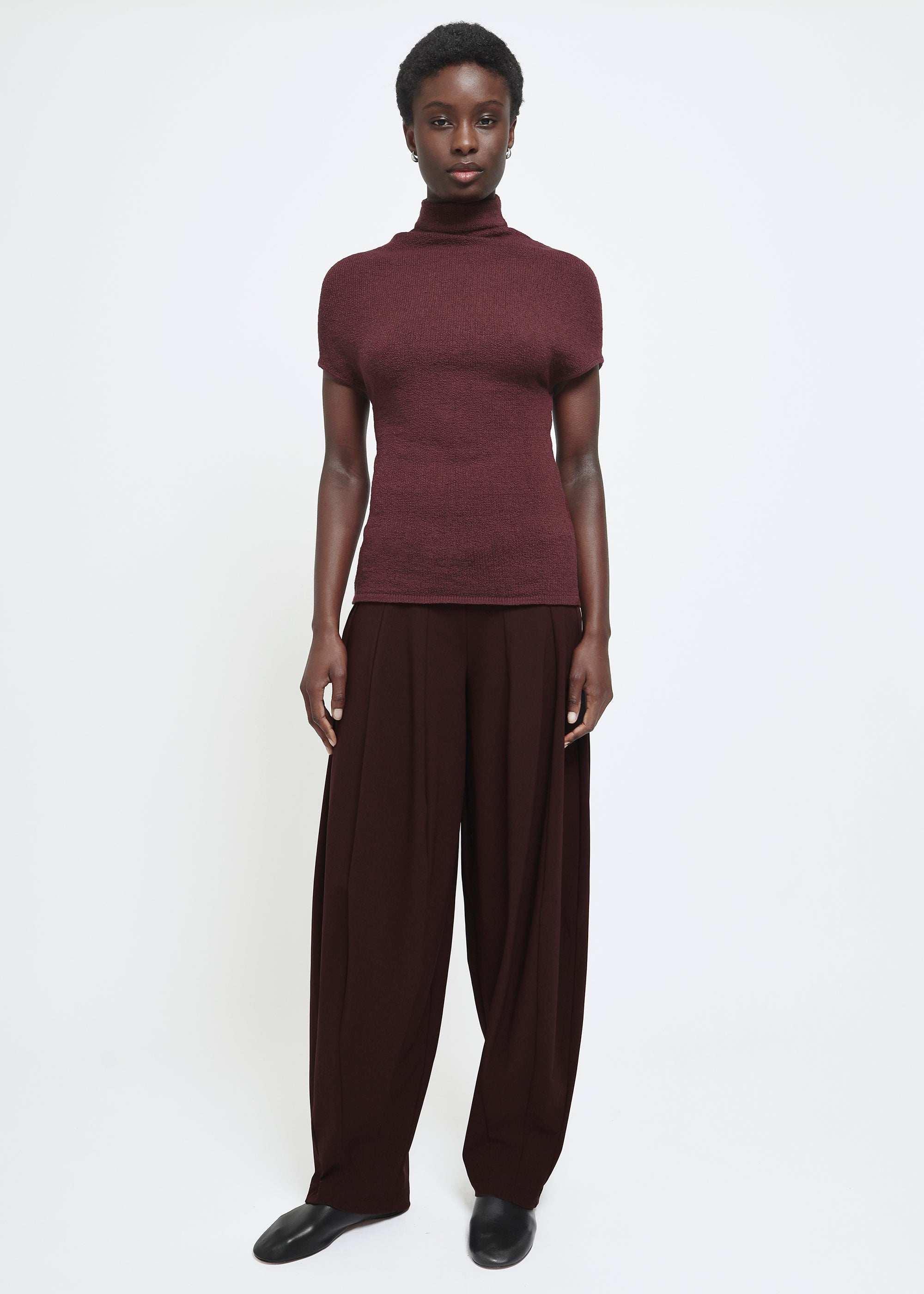 A wide-leg dark burgundy curved trousers.