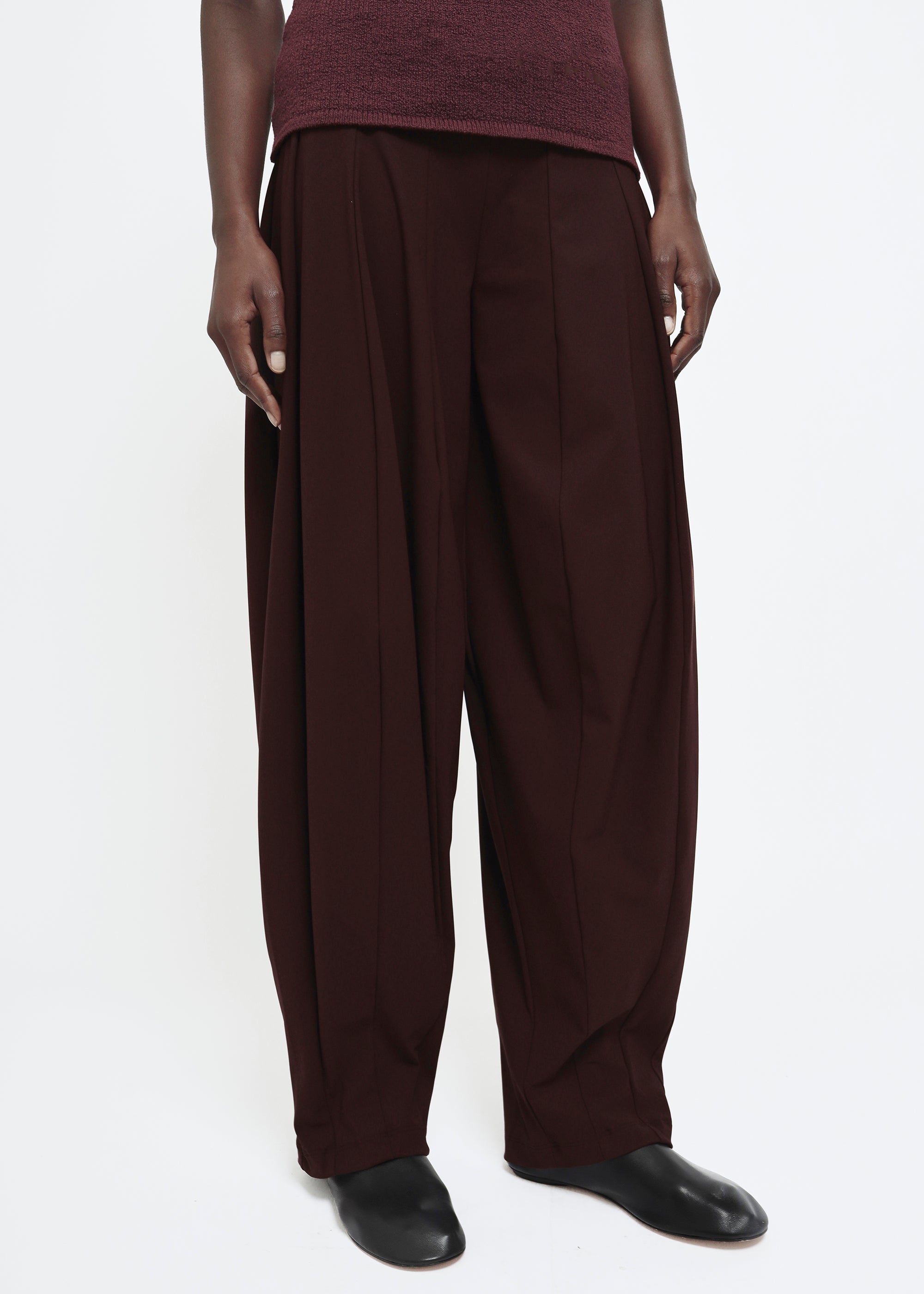 A wide-leg dark burgundy curved trousers.