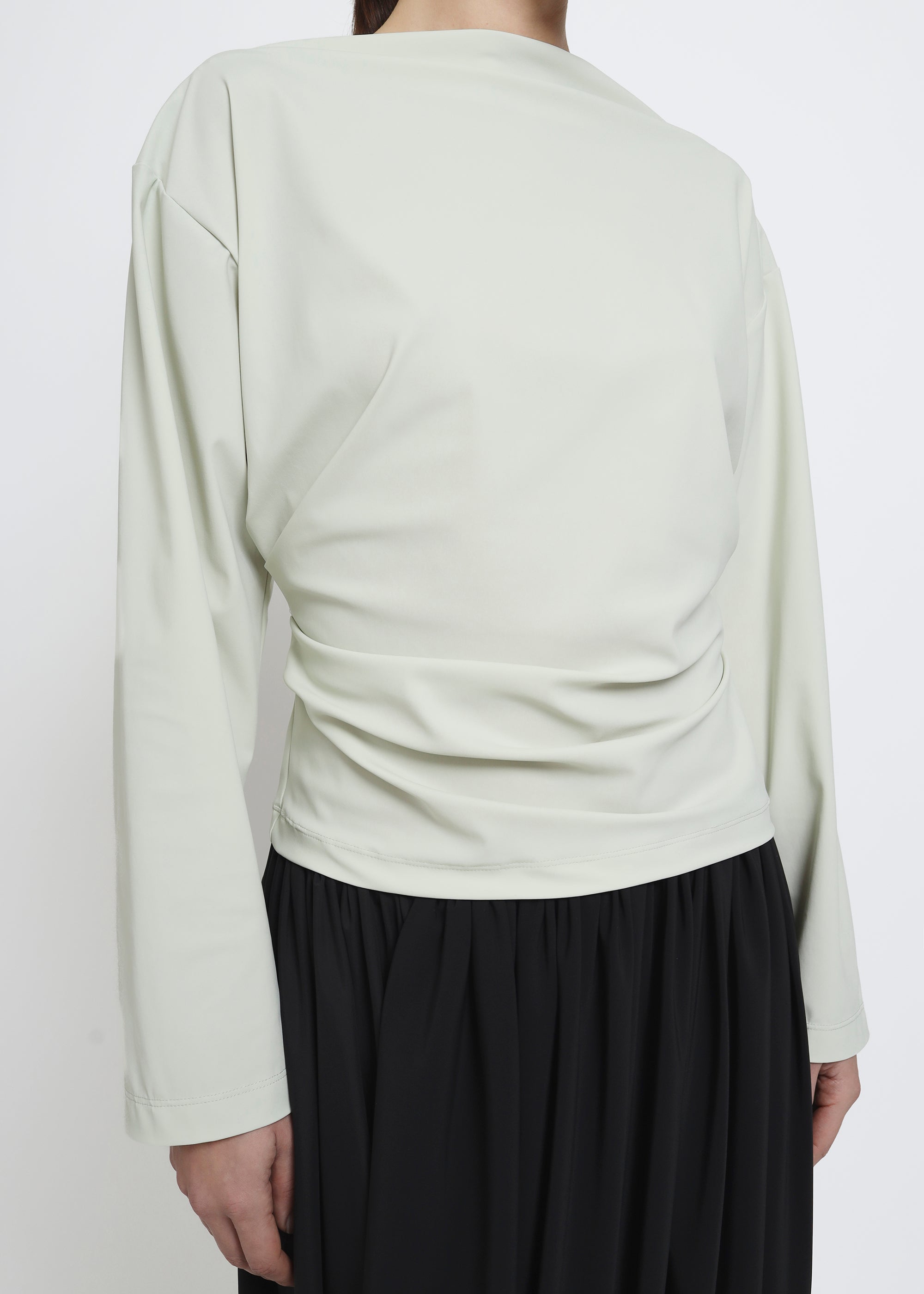 A light sage green long-sleeve top.
