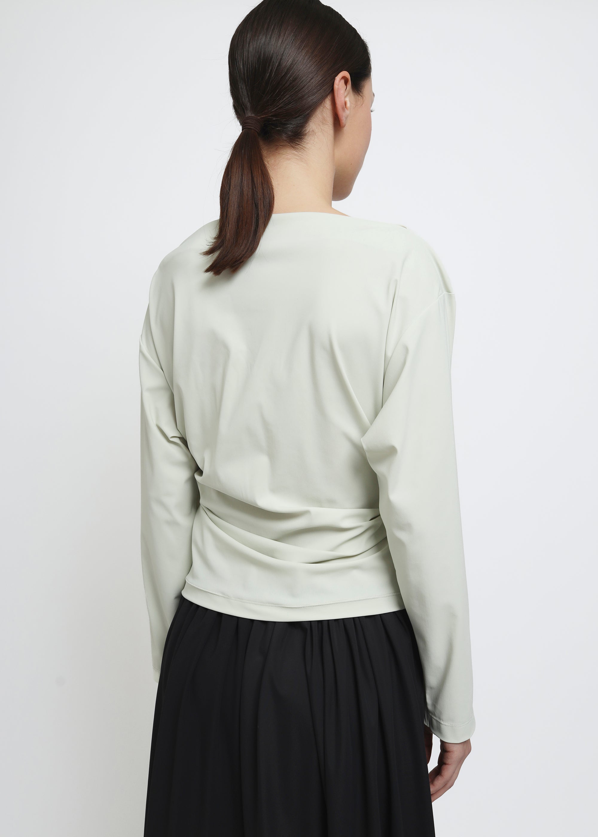 A light sage green long-sleeve top.