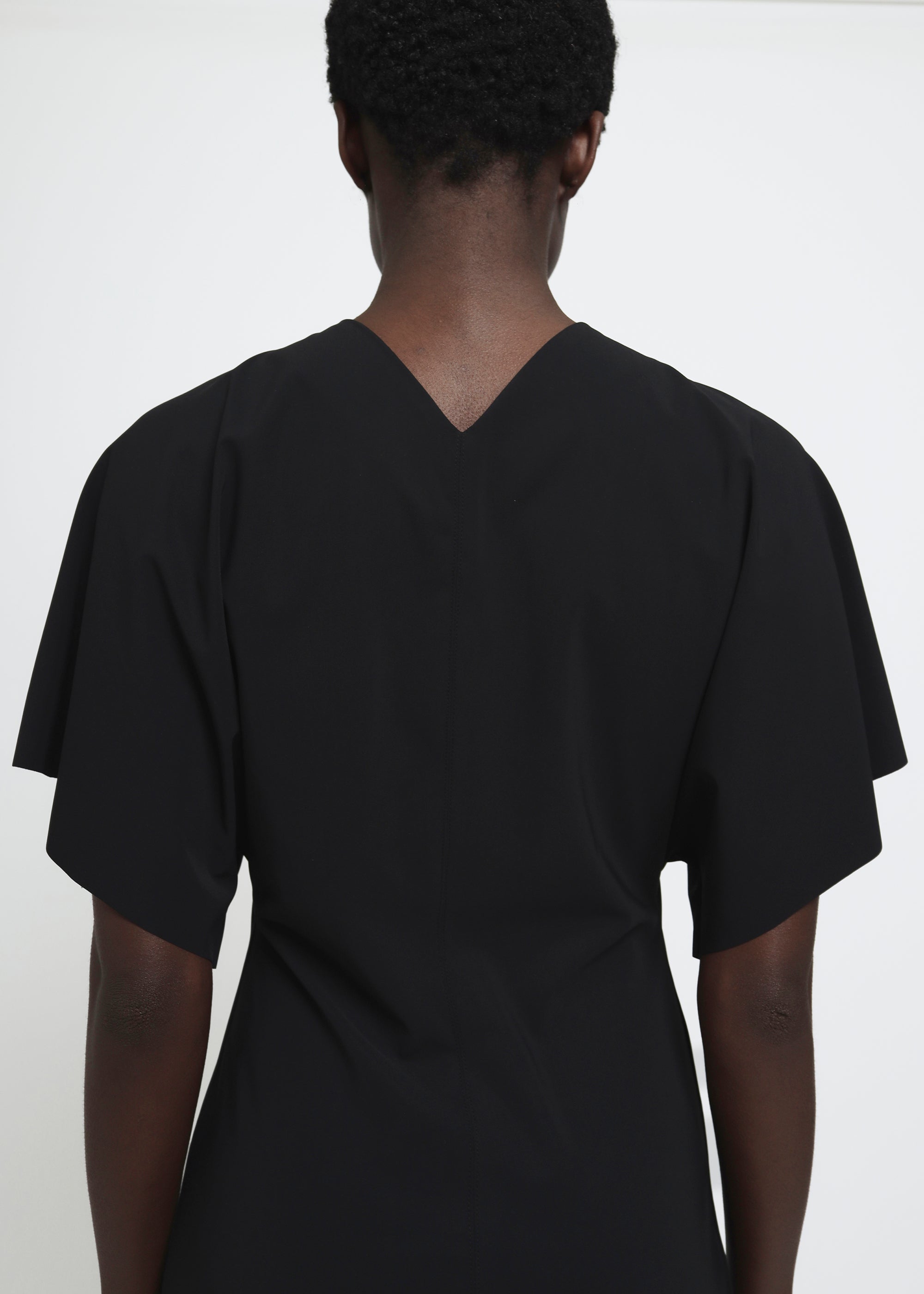 A black midi dress with short flutter sleeves.
