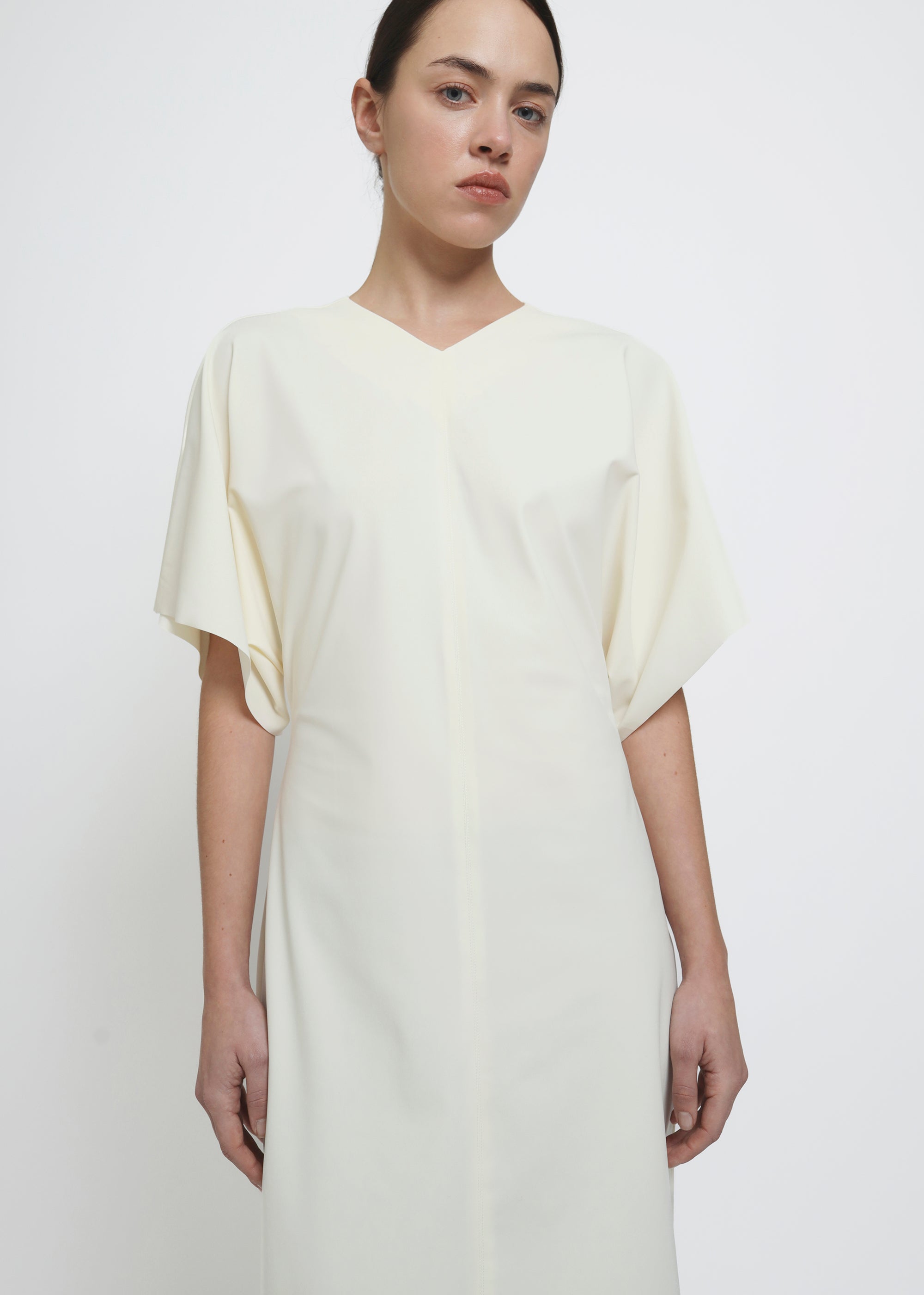 A cream-colored midi dress with short flutter sleeves.