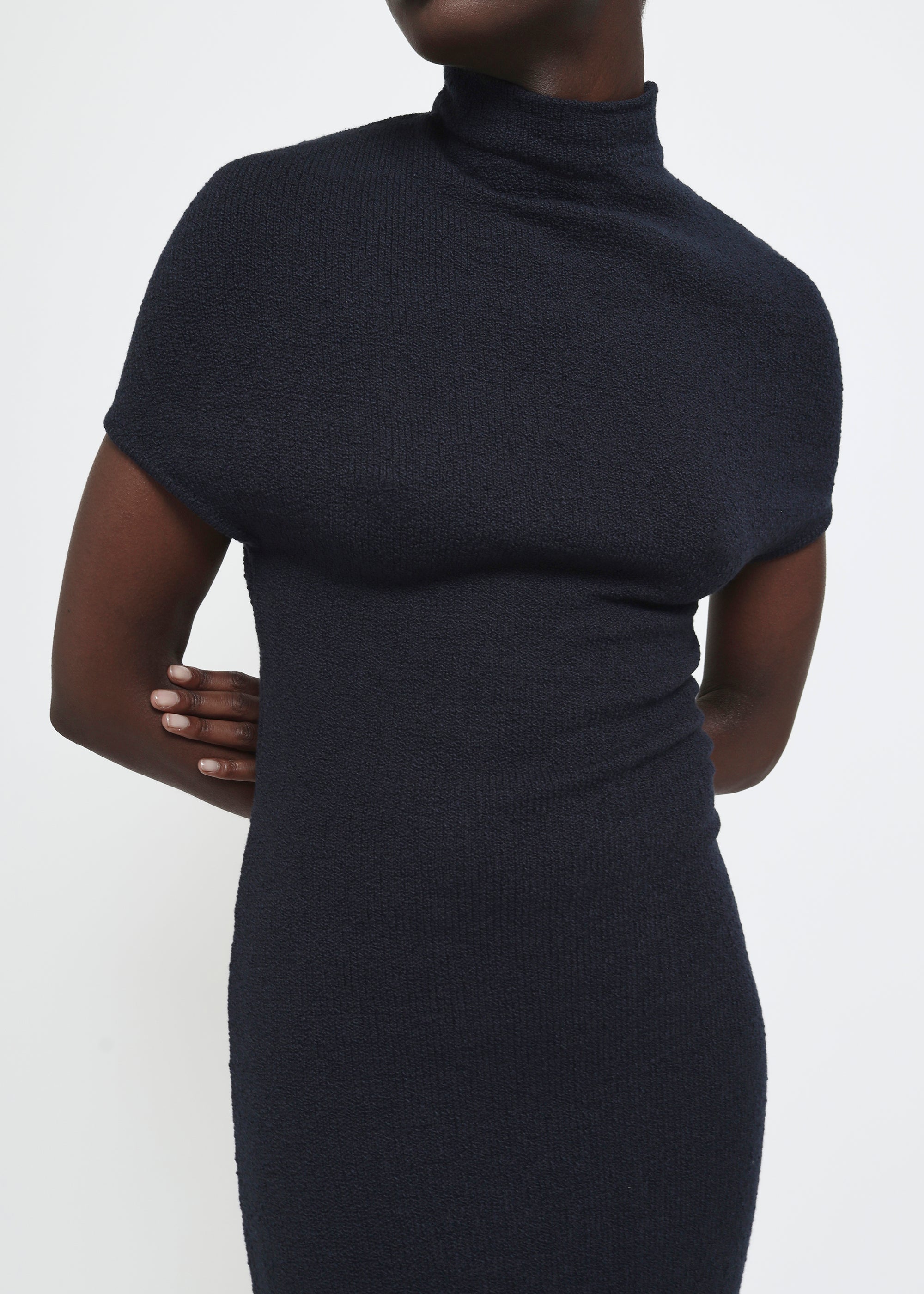 A navy cap-sleeve mock neck midi dress in a textured yarn.
