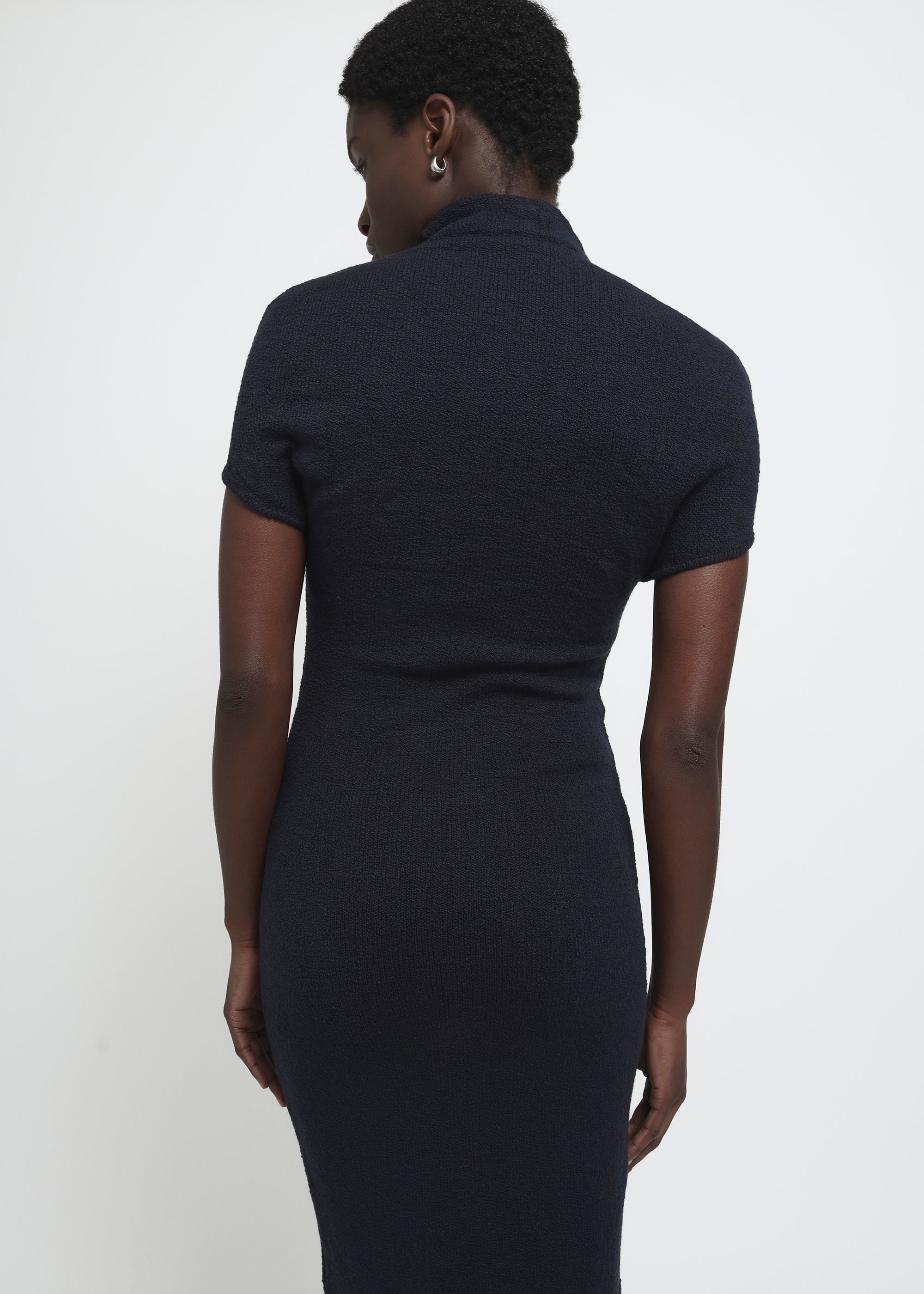 A navy cap-sleeve mock neck midi dress in a textured yarn.