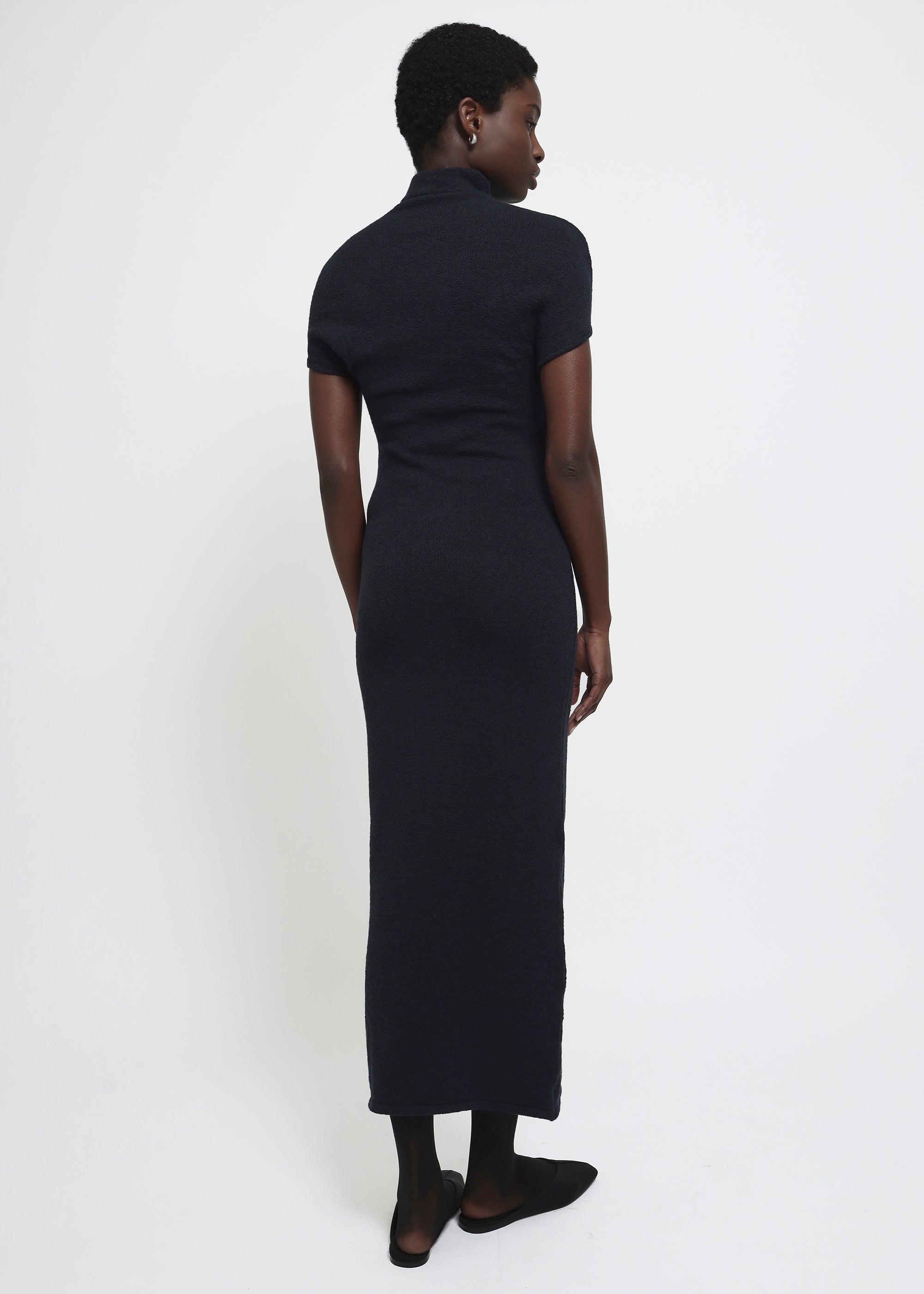 A navy cap-sleeve mock neck midi dress in a textured yarn.