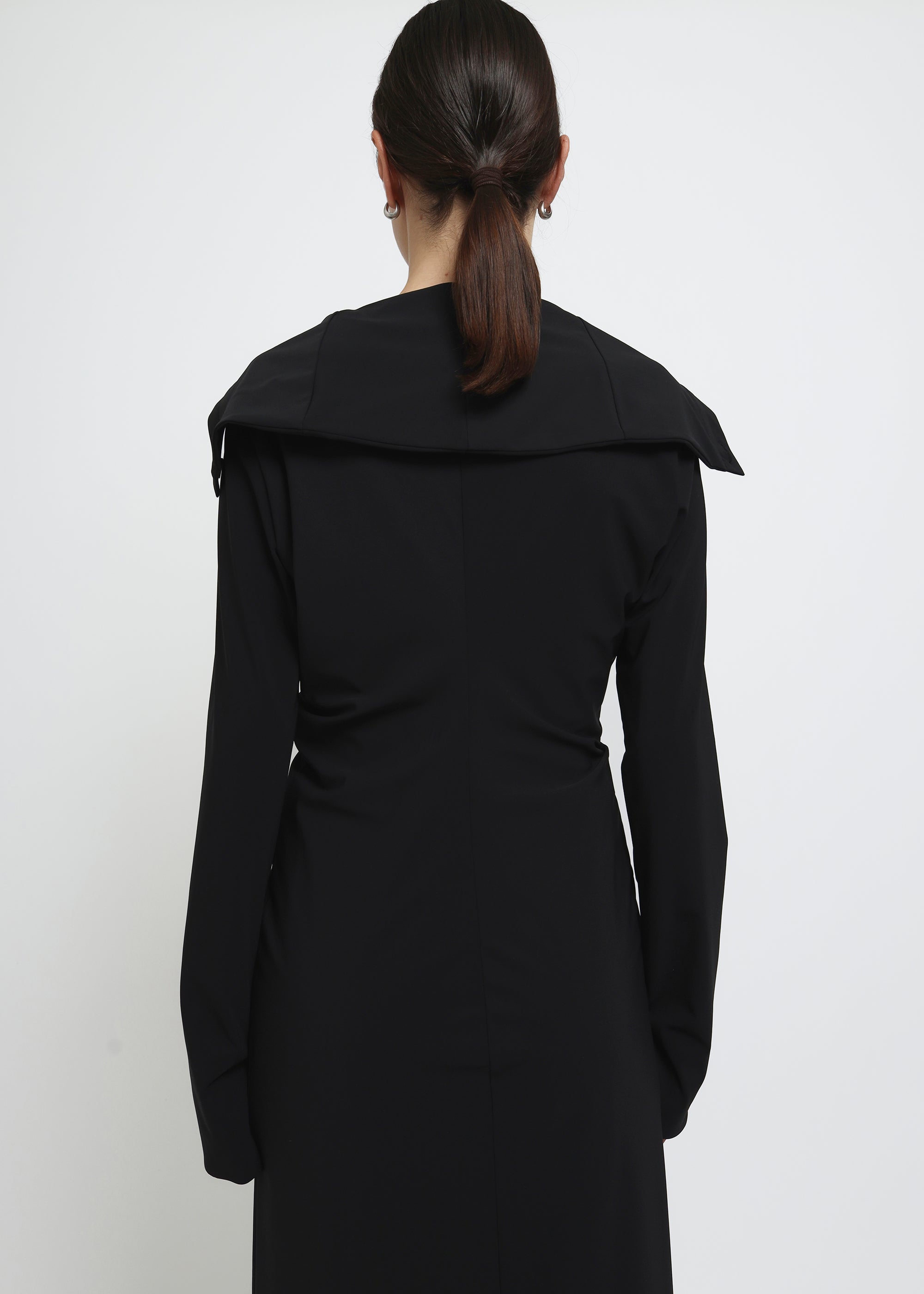 A long black button-front cardigan dress with wide lapels and draped shoulders.