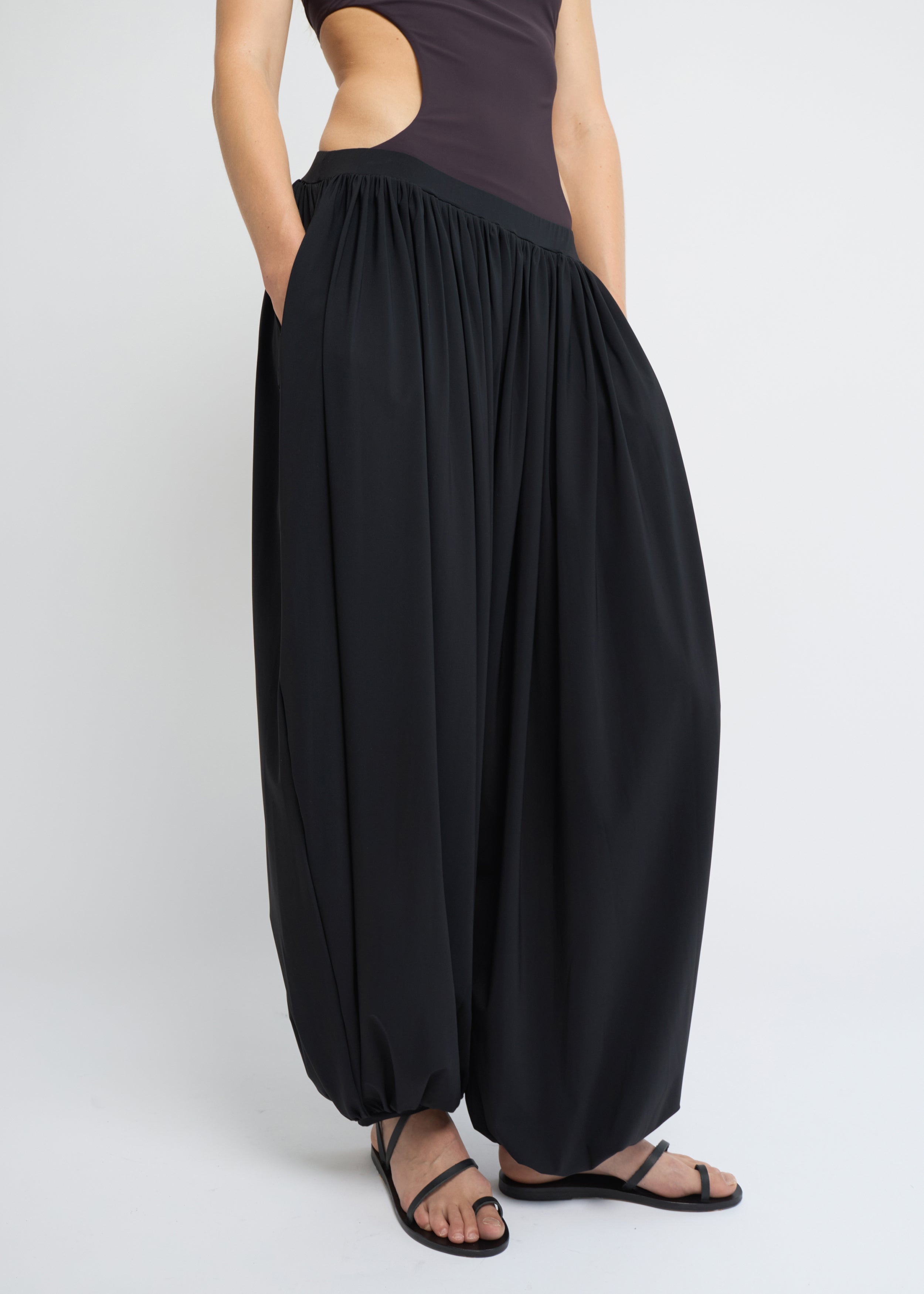Black balloon pants with voluminous silhouette and gathered hems