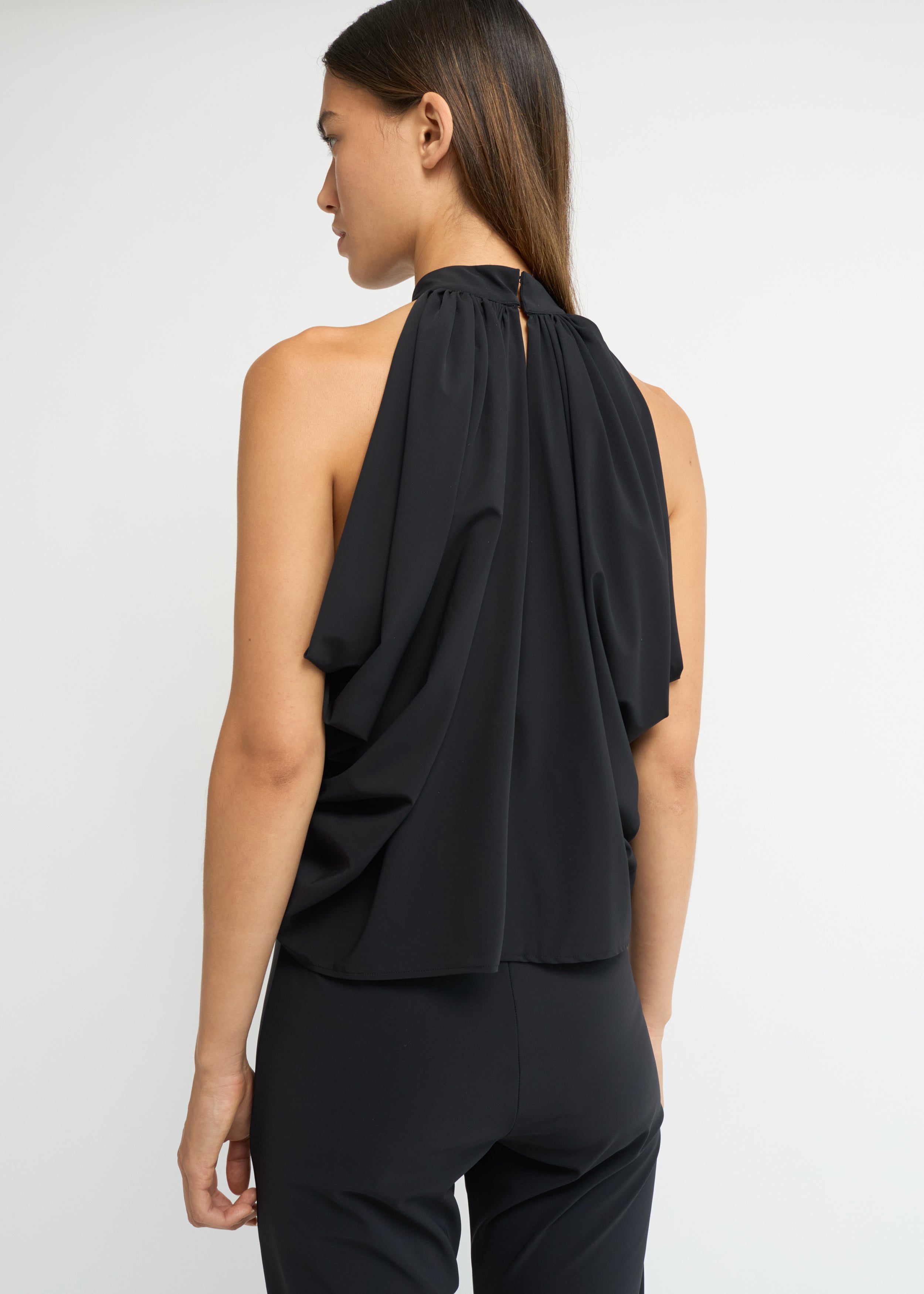 Black sleeveless balloon top with a gathered high neckline and voluminous silhouette