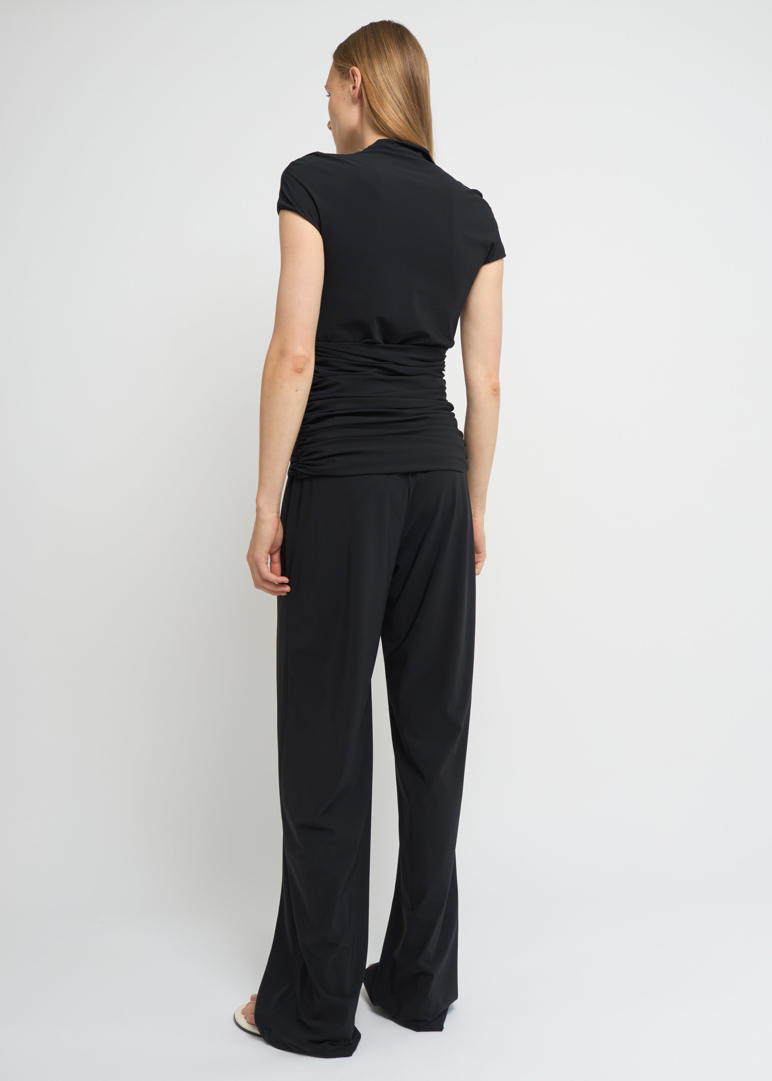 Black fitted short-sleeve top with a high neckline and soft gathers at the waist