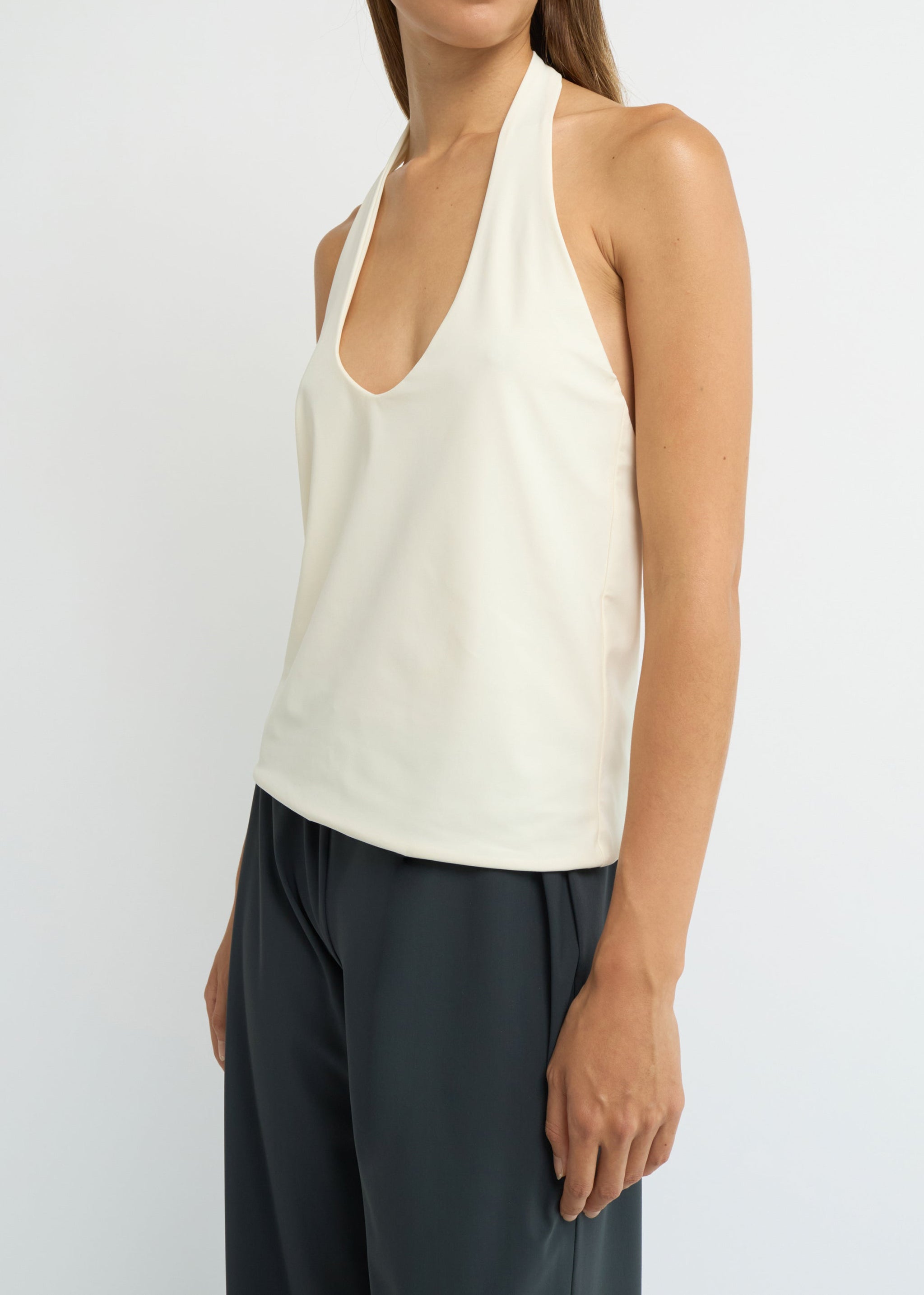 Cream halter neck top with a deep scoop neckline and open back